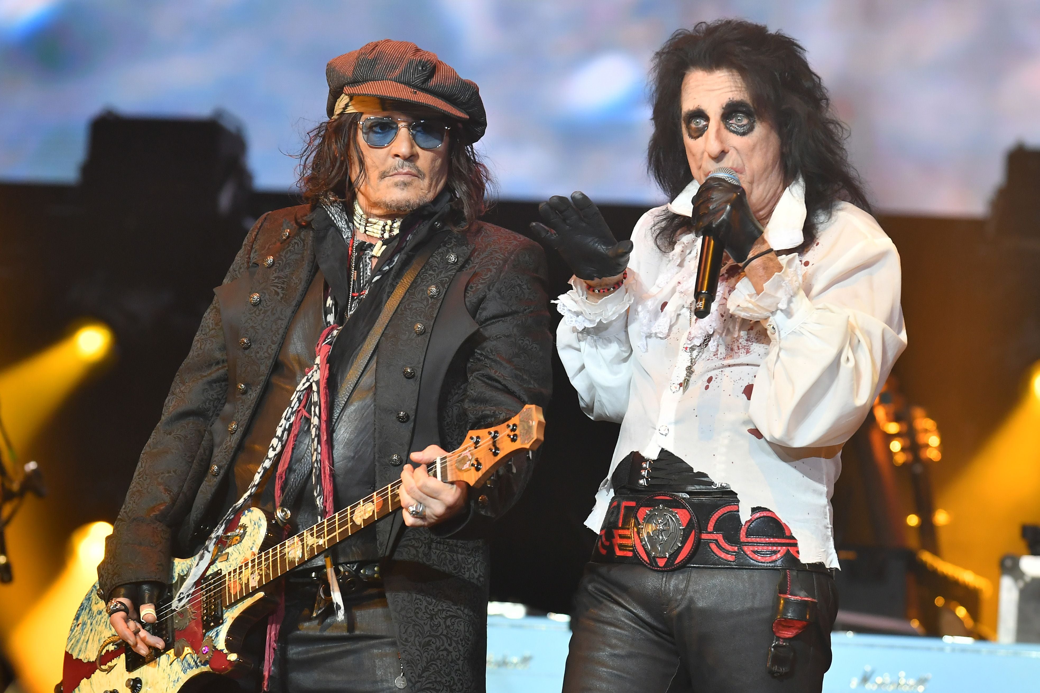 Zwei Musiker der Hollywood Vampires auf der Bühne, einer spielt Gitarre, der andere singt.