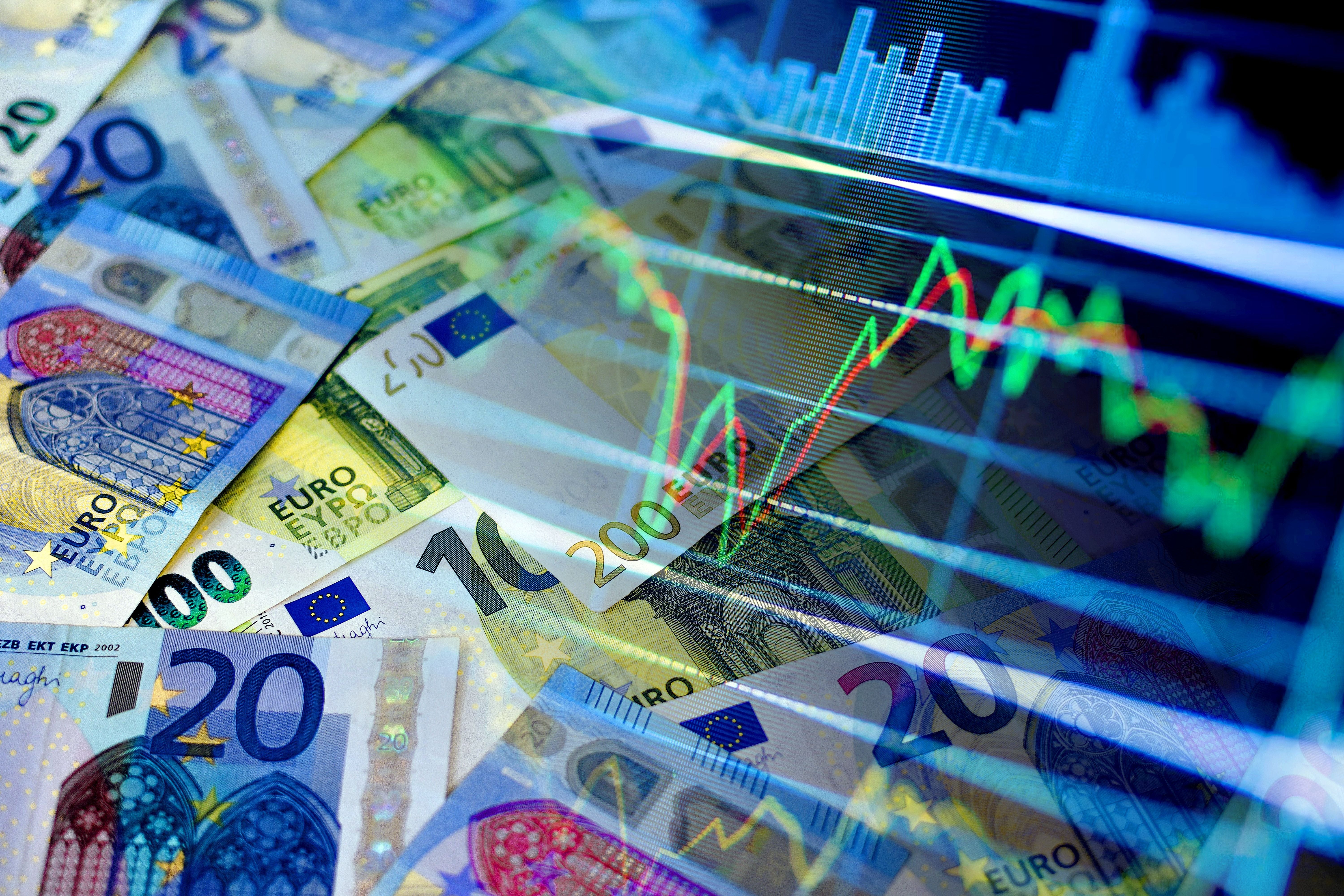 Verschiedene Euro-Geldscheine mit überlagerter Börsengrafik und Kurslinien.