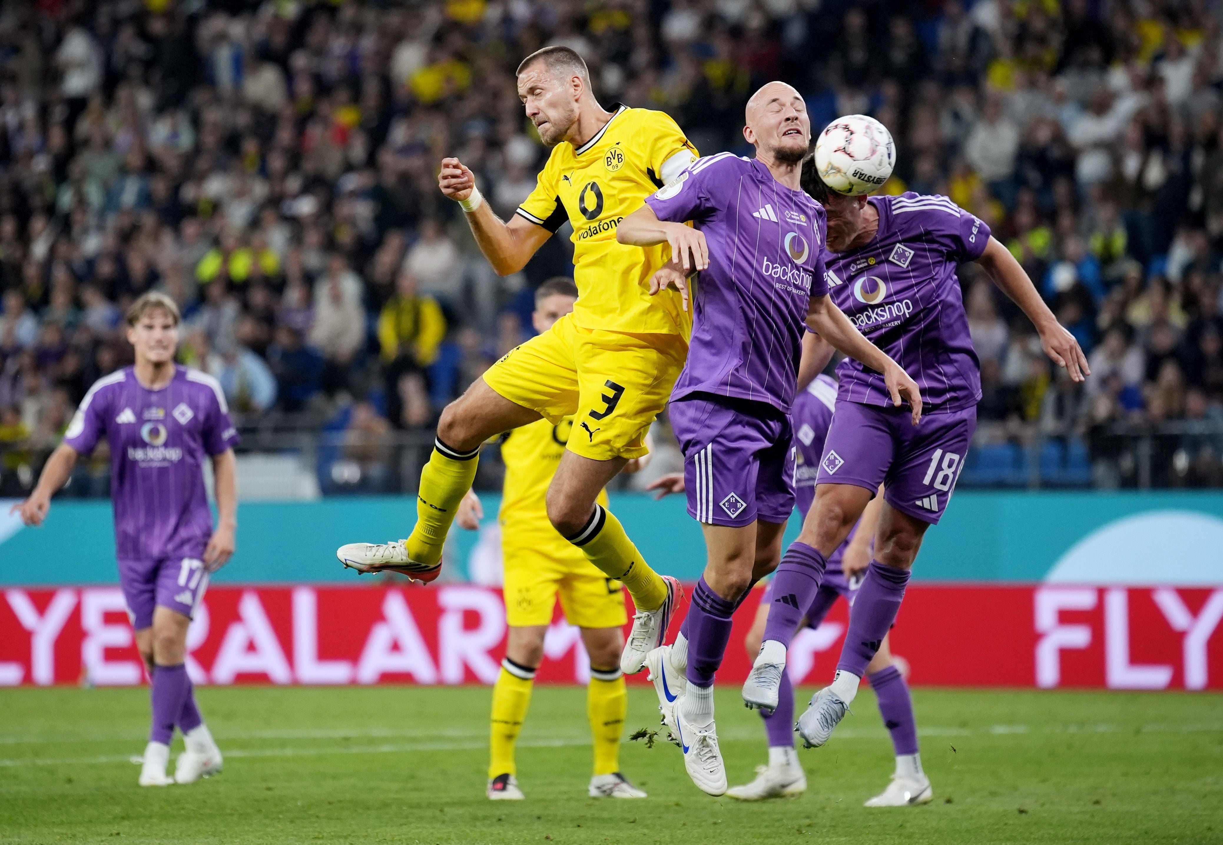 Ein Spieler von Dortmund und zwei Spieler von Hamburg kämpfen um den Ball per Kopf.
