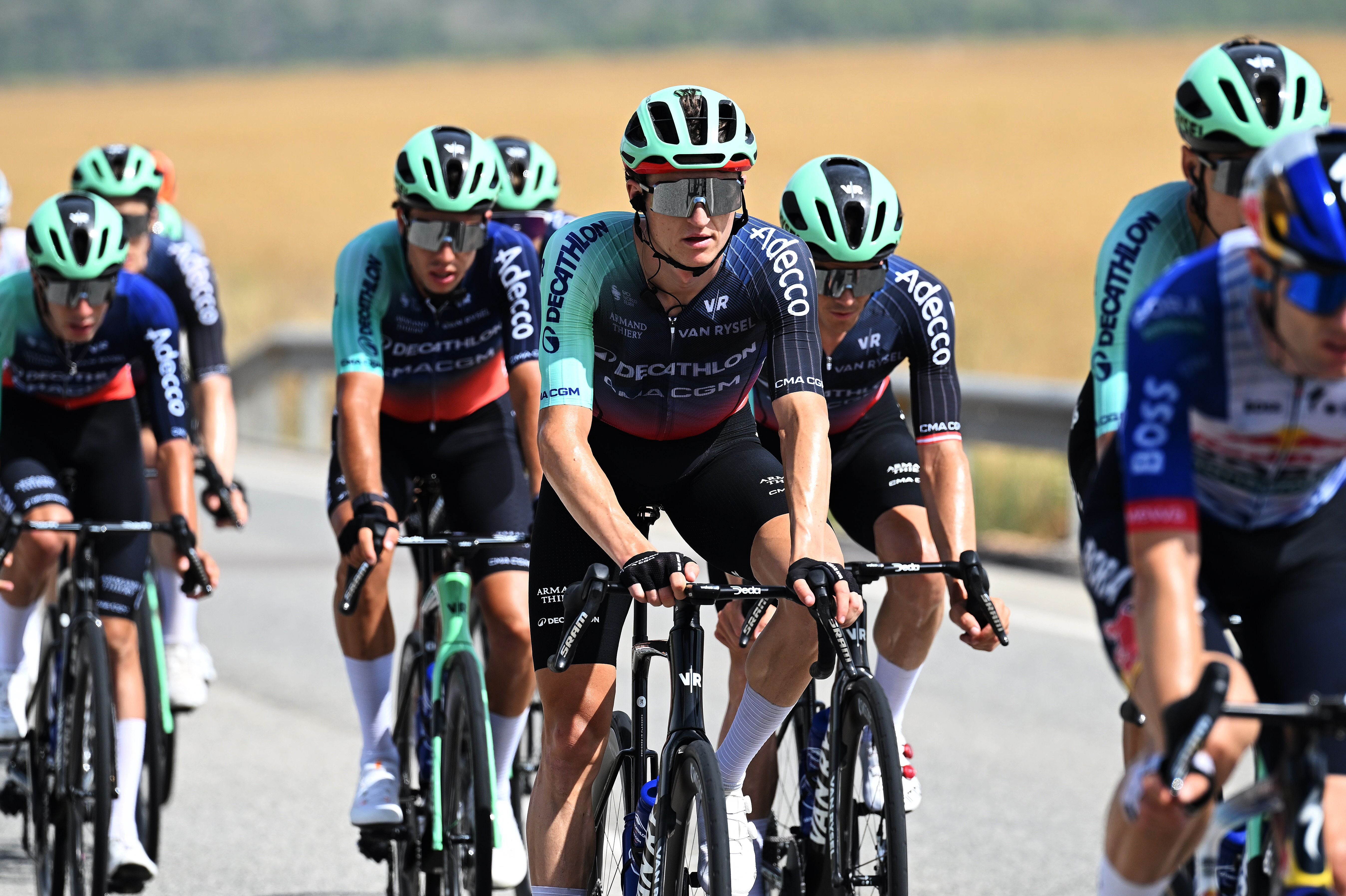 Radrennfahrer der Team Decathlon CMA CGM fahren während eines Rennens auf einer Landstraße.