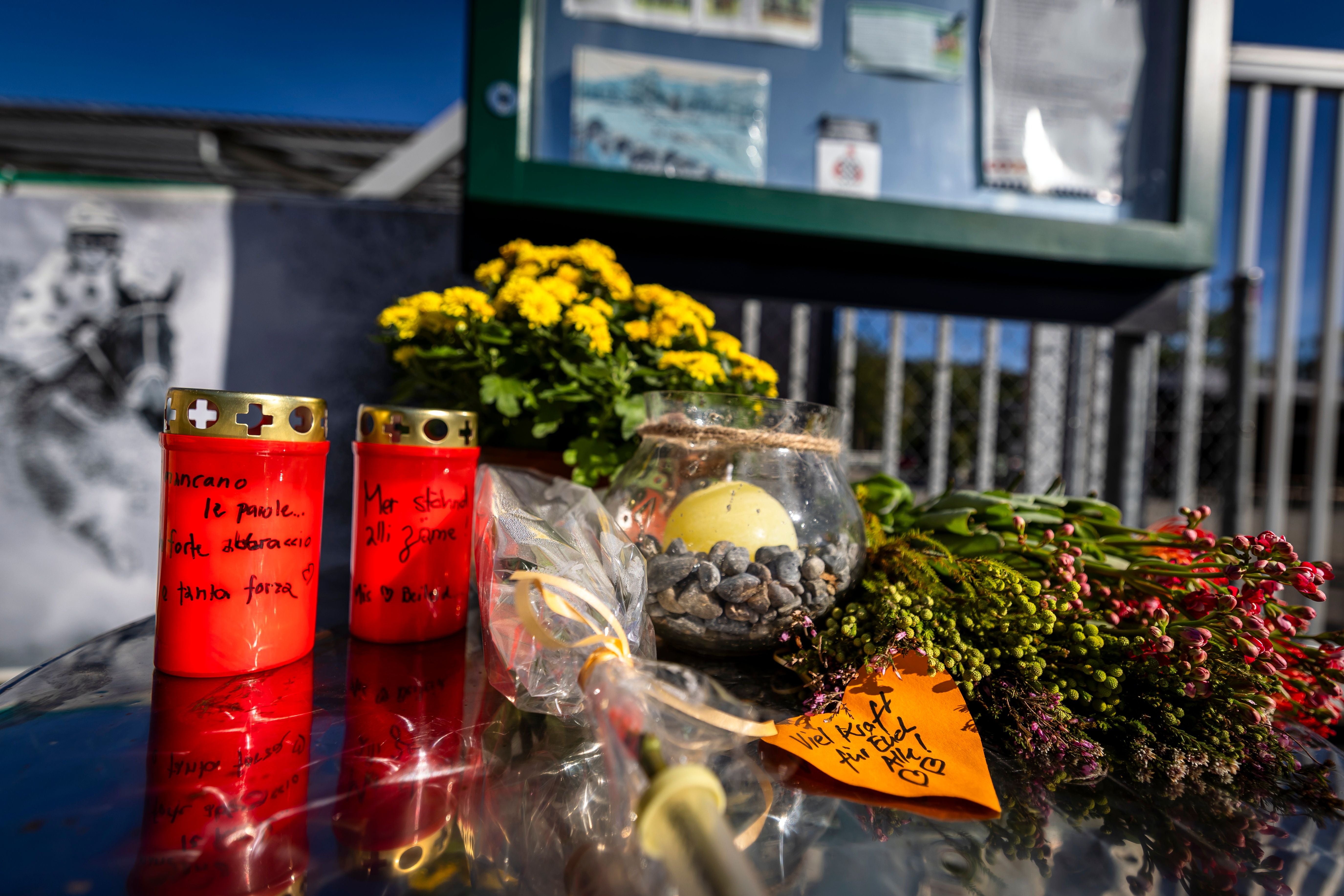 Blumen, Kerzen und handgeschriebene Notizen vor dem Eingang einer Pferderennbahn als Gedenkstätte.