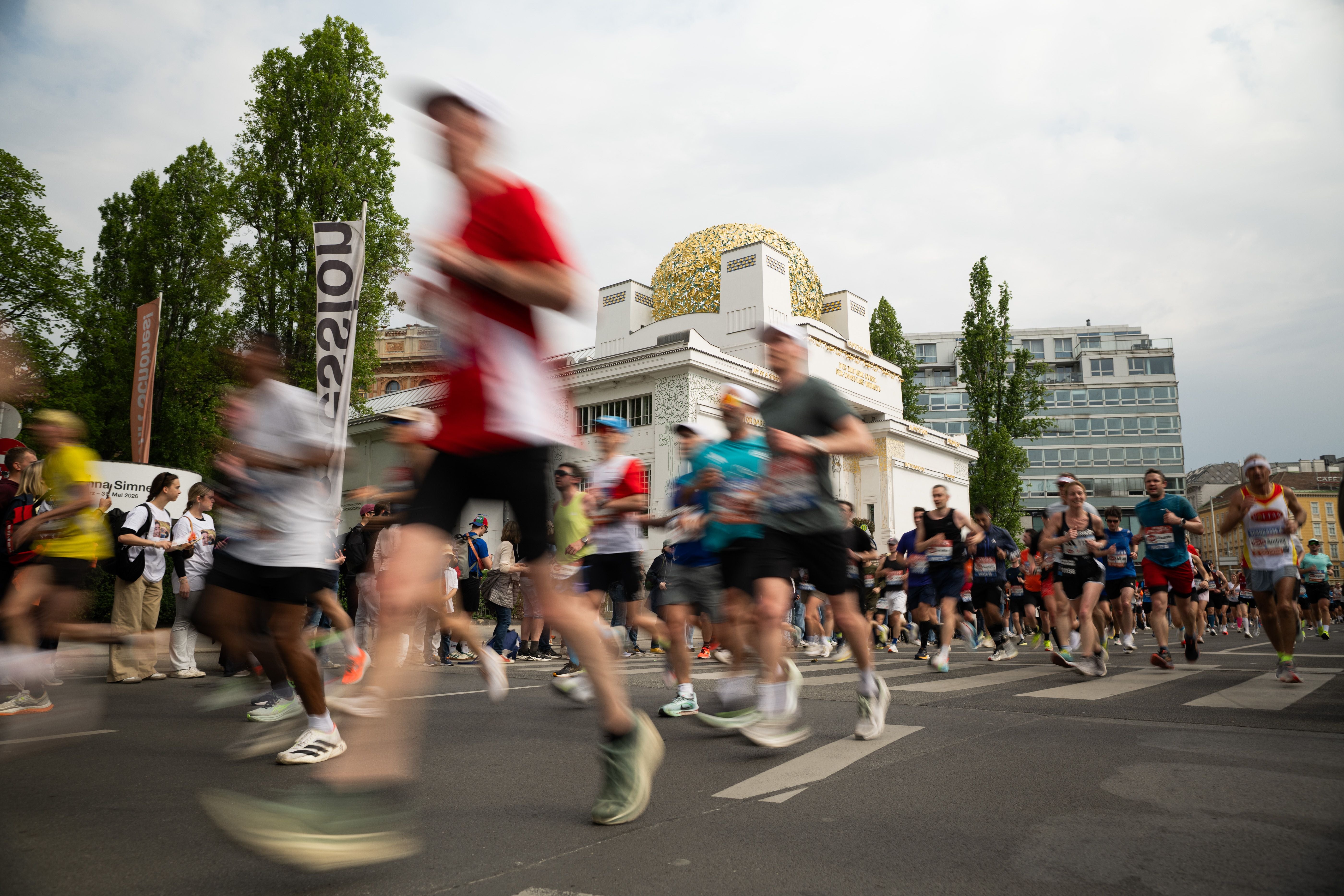Viele Marathonläufer rennen am Secessionsgebäude in Wien bei einem Stadtmarathon vorbei.