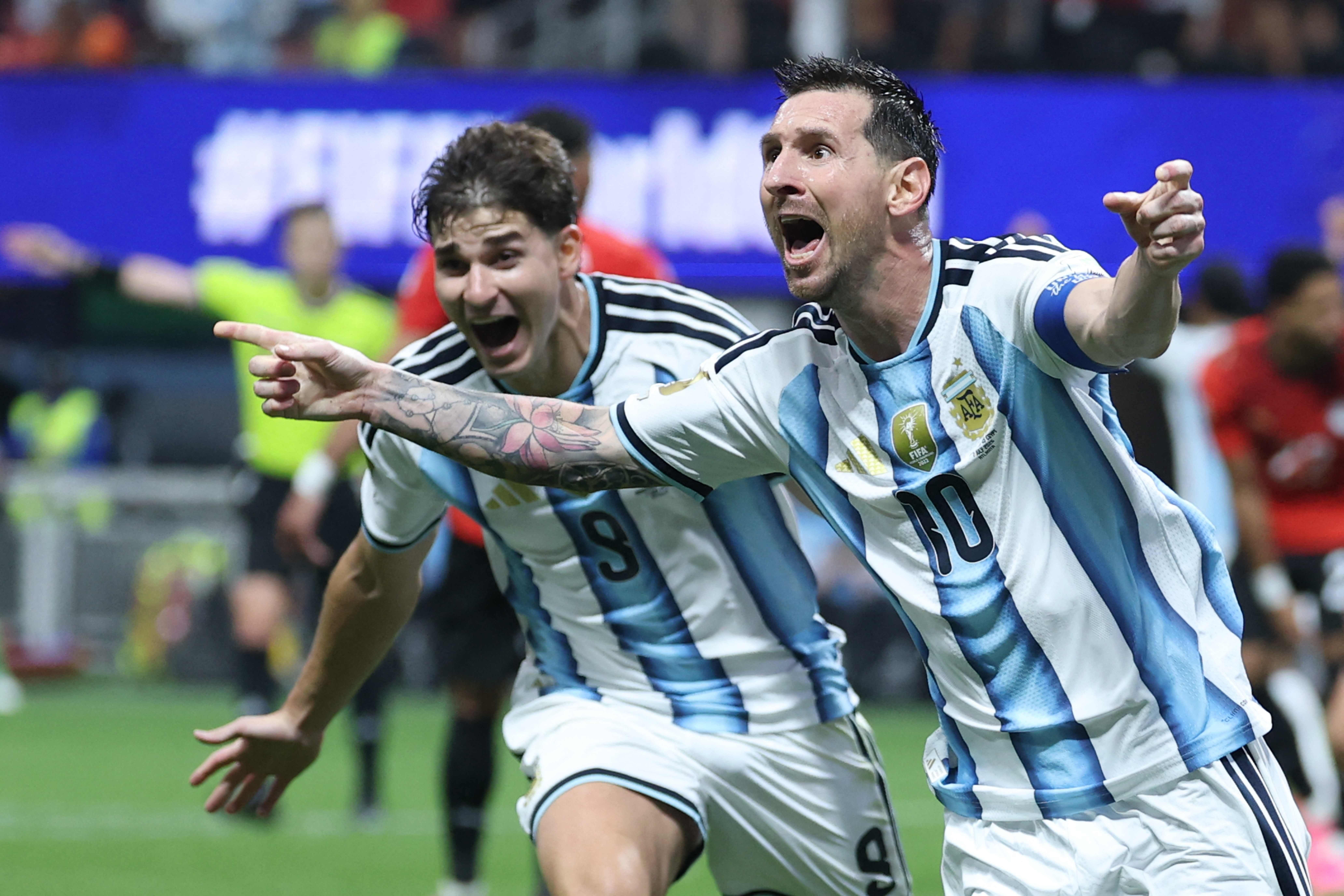 Lionel Messi jubelt mit einem Mitspieler im argentinischen Trikot nach einem Tor auf dem Fußballfeld.