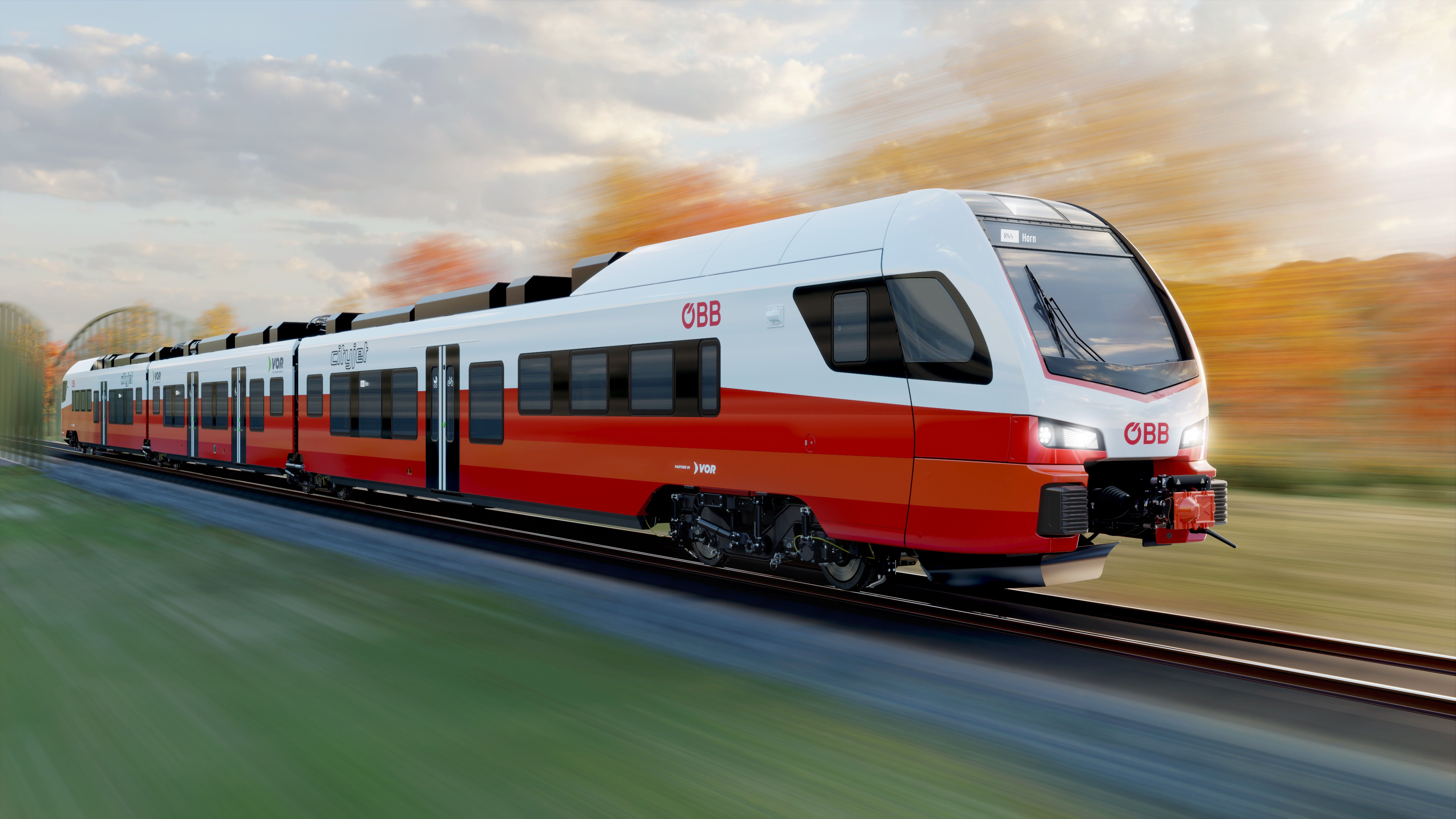 Moderner ÖBB Cityjet Akkutriebzug fährt schnell durch herbstliche Landschaft.
