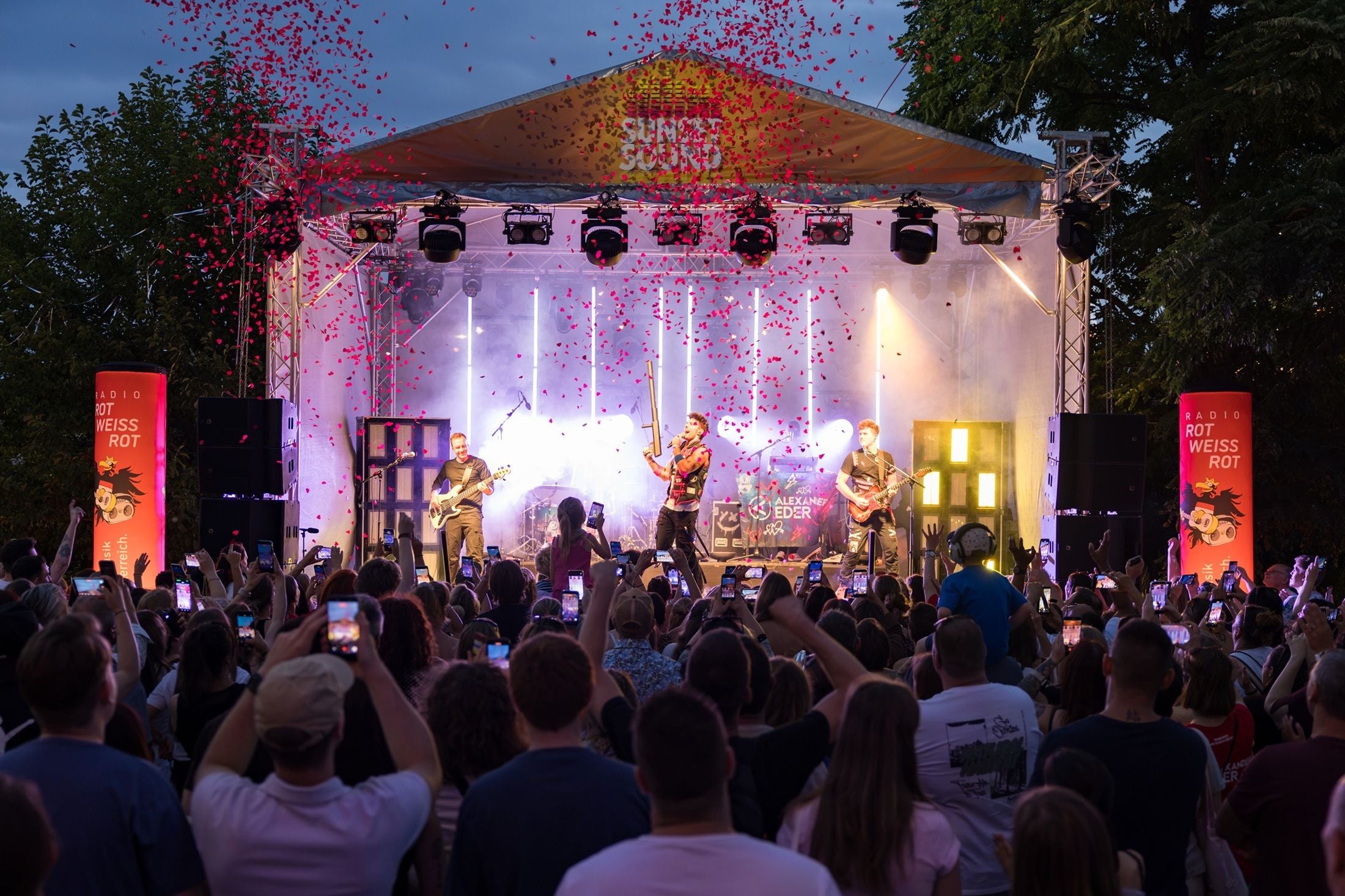 Open-Air-Konzert bei Sonnenuntergang mit Band, Konfetti und jubelndem Publikum auf den Multiplex Terrassen.