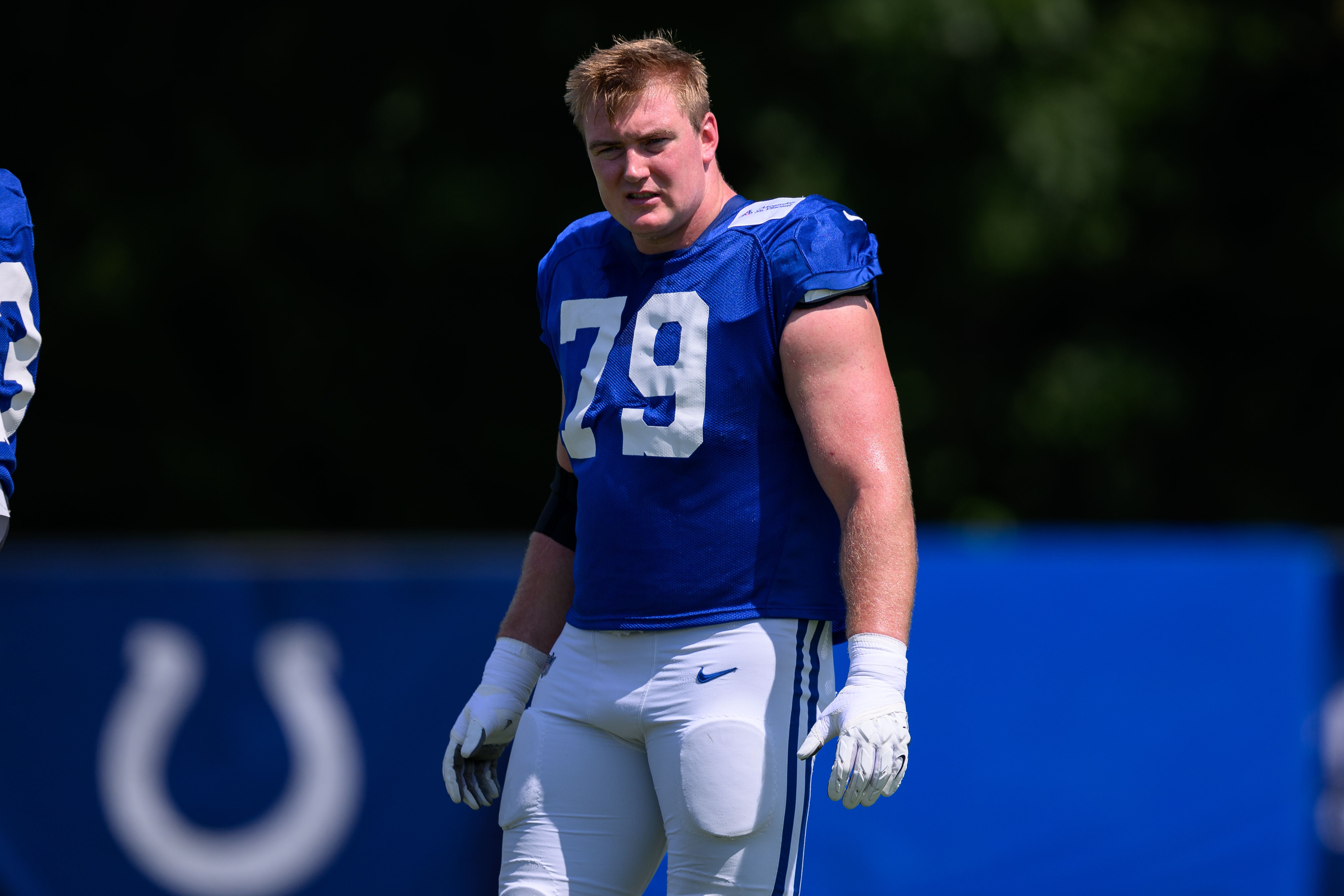 Ein Footballspieler der Colts mit der Nummer 79 trainiert im Freien auf einem Sportplatz.