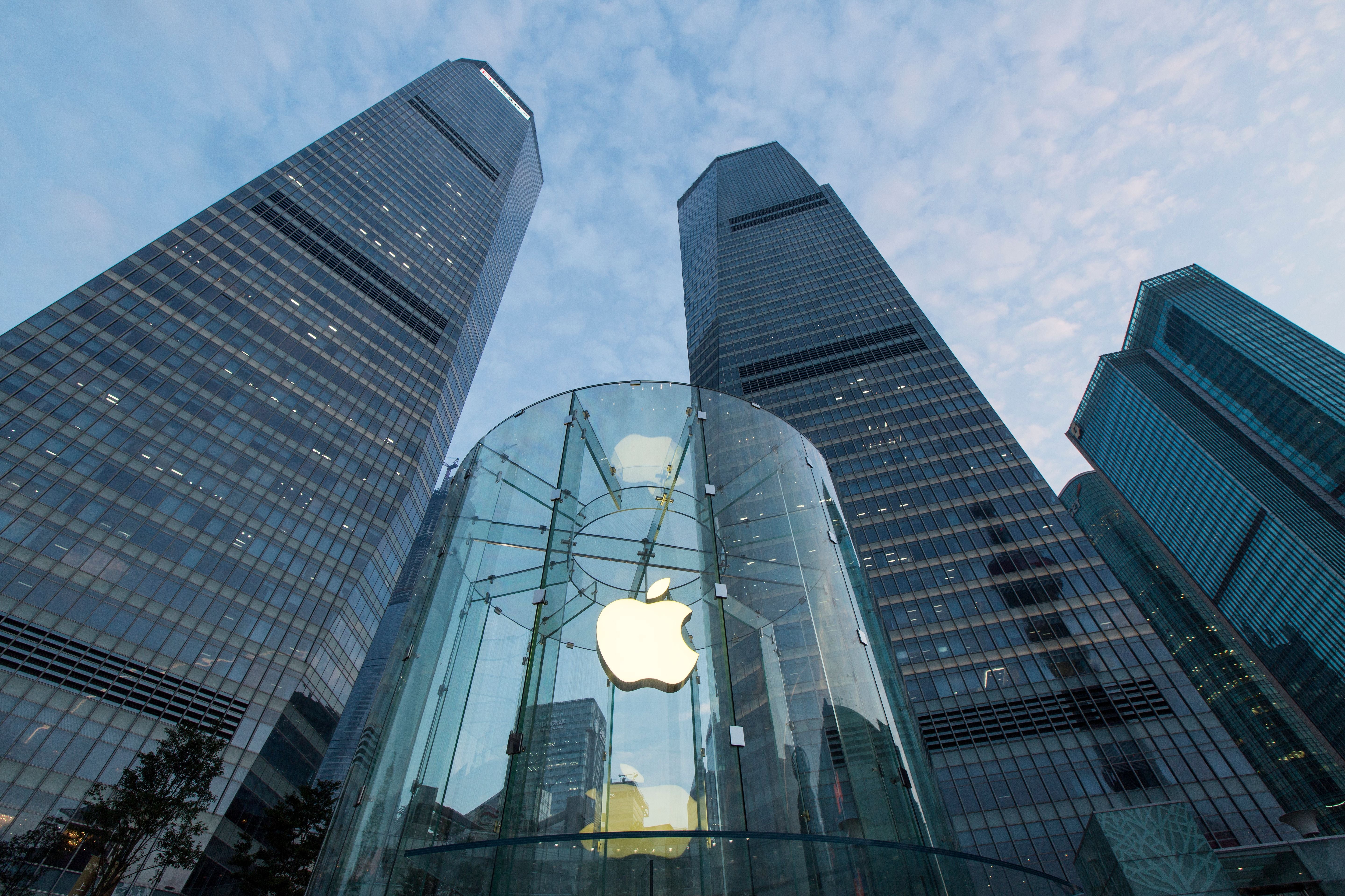 Apple Store Eingang mit gläserner Fassade und Apple-Logo, flankiert von Hochhäusern in Shanghai.