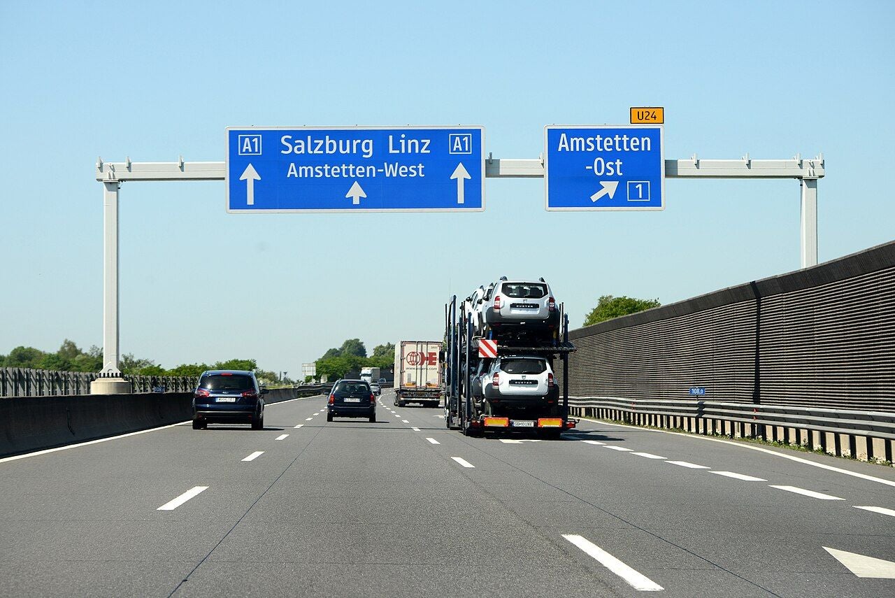 Autobahn A1 mit Wegweisern nach Salzburg, Linz und Amstetten-Ost, mehrere Autos auf der Fahrbahn.