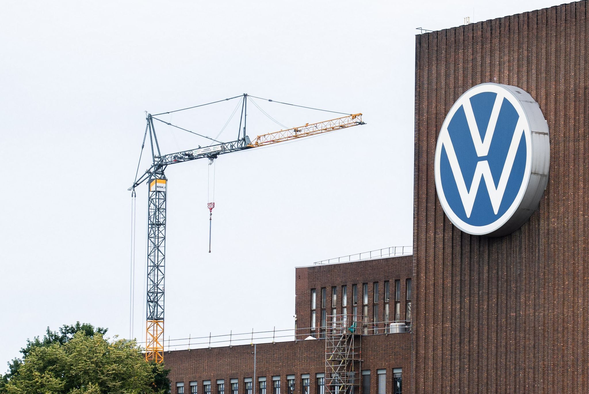 Baukran am Heizkraftwerk des VW-Stammwerks in Wolfsburg mit großem VW-Logo an der Fassade.