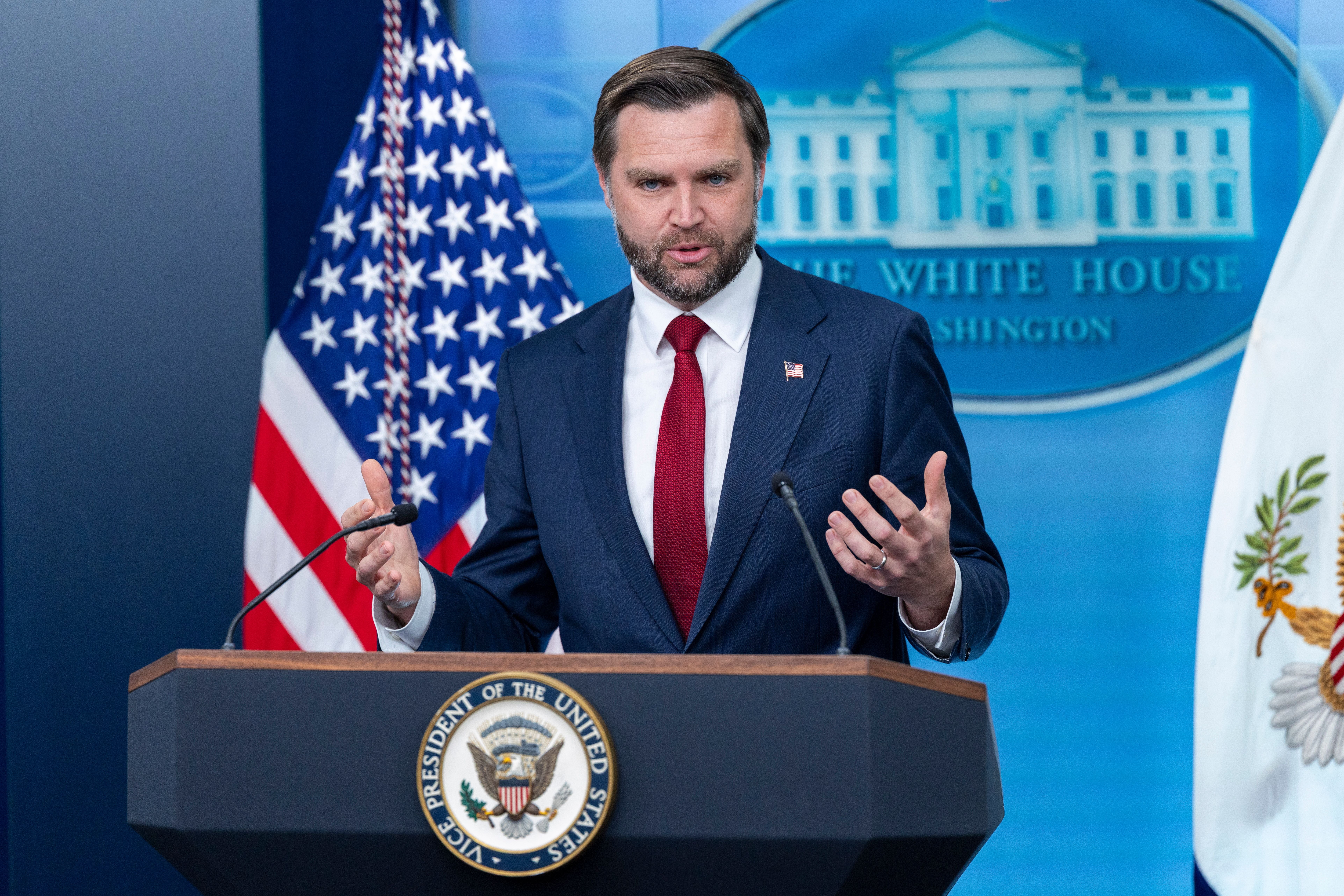 Ein Mann im Anzug spricht bei einer Pressekonferenz im Weißen Haus an einem Rednerpult.