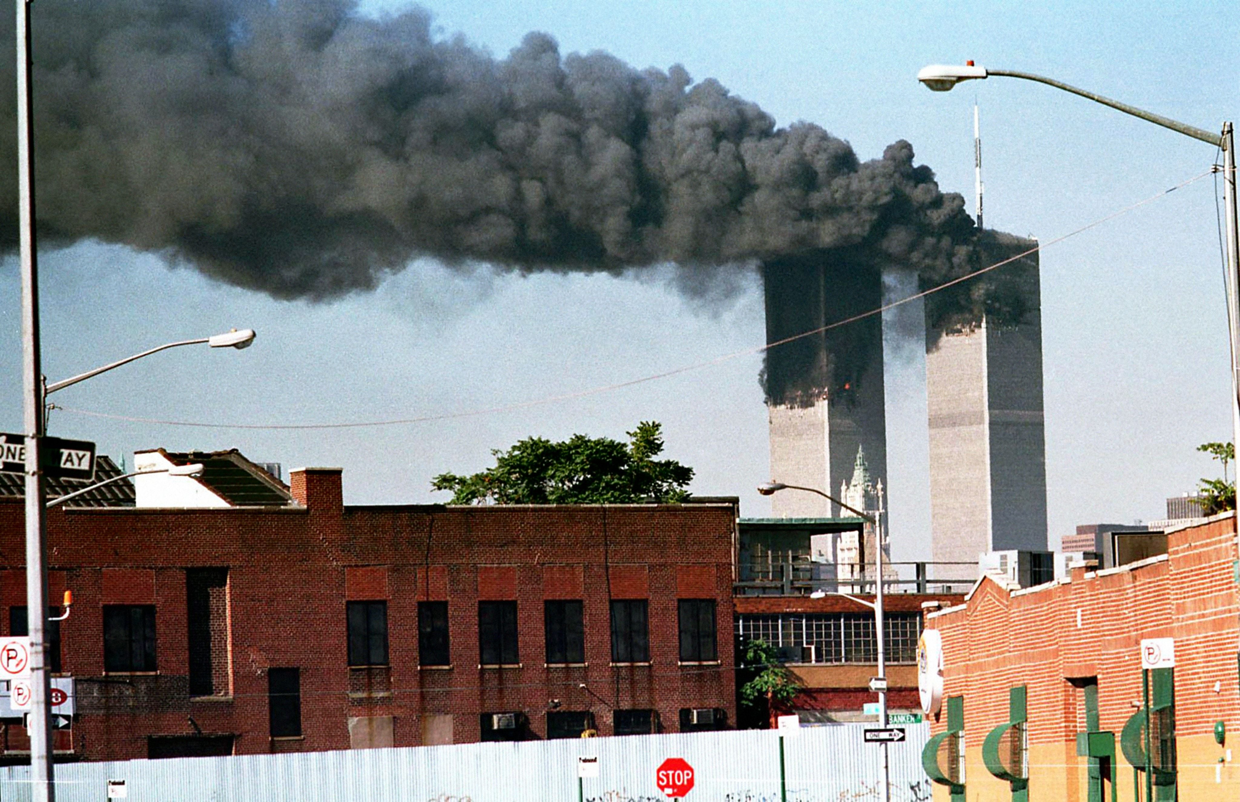 Dichte schwarze Rauchwolken steigen aus den brennenden Twin Towers des World Trade Centers auf.