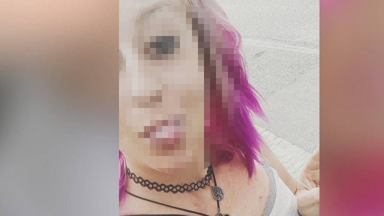 Person mit pinken Haaren und verpixeltem Gesicht, im Freien, trägt Halsketten.
