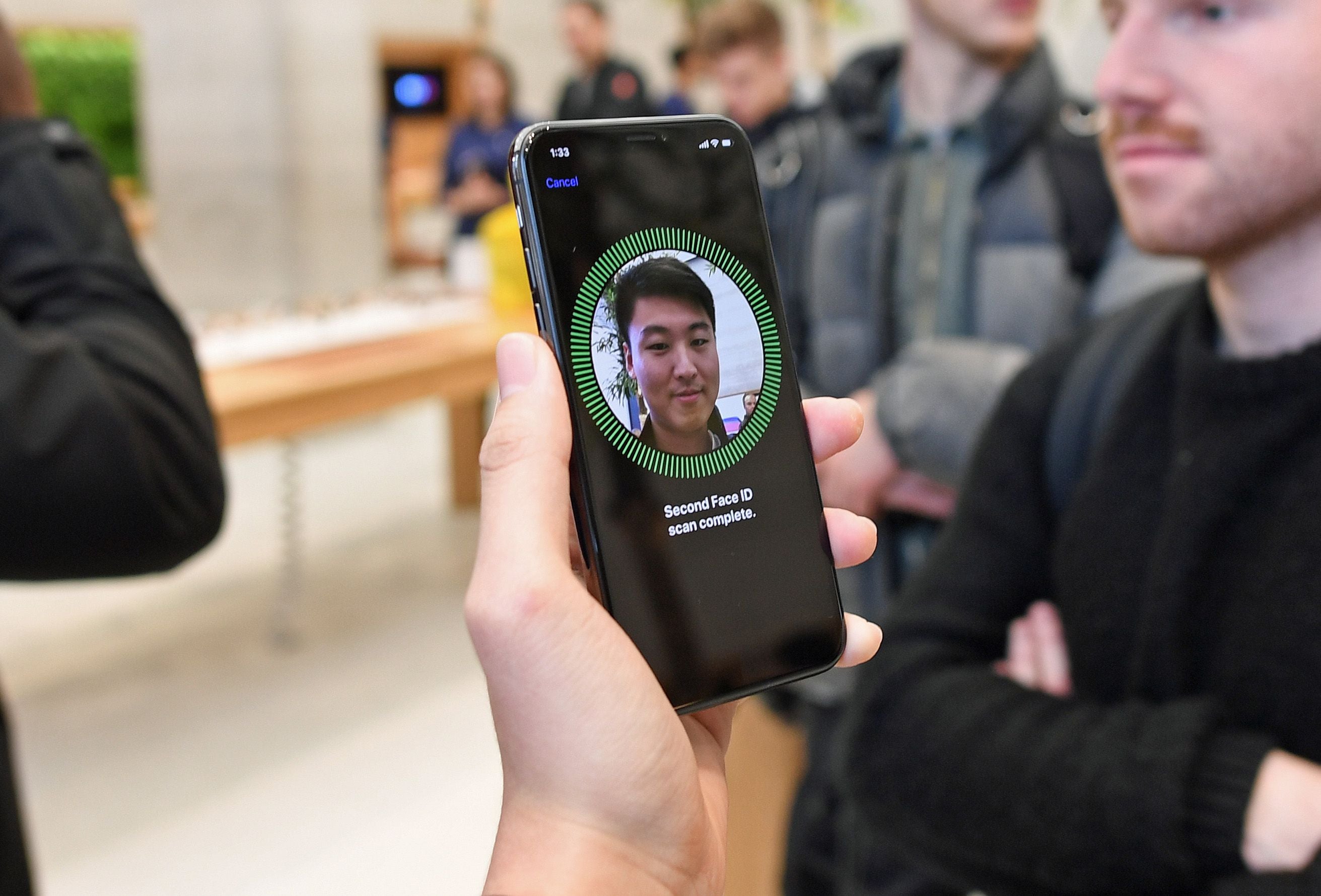 Eine Person richtet Face ID auf einem iPhone X in einem Apple Store ein.