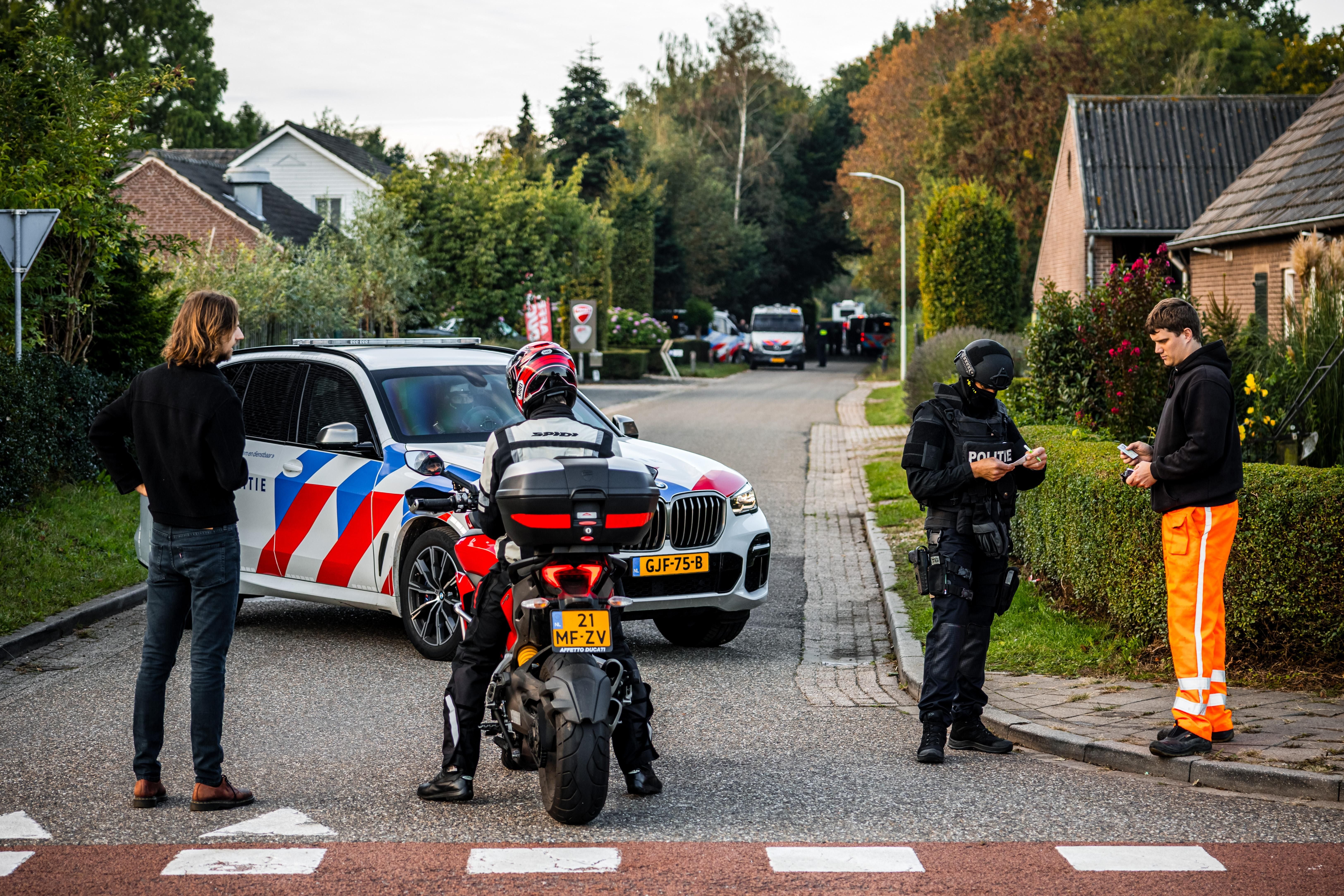 Polizisten sichern eine abgesperrte Straße nach einer Schießerei in Overasselt, Niederlande.