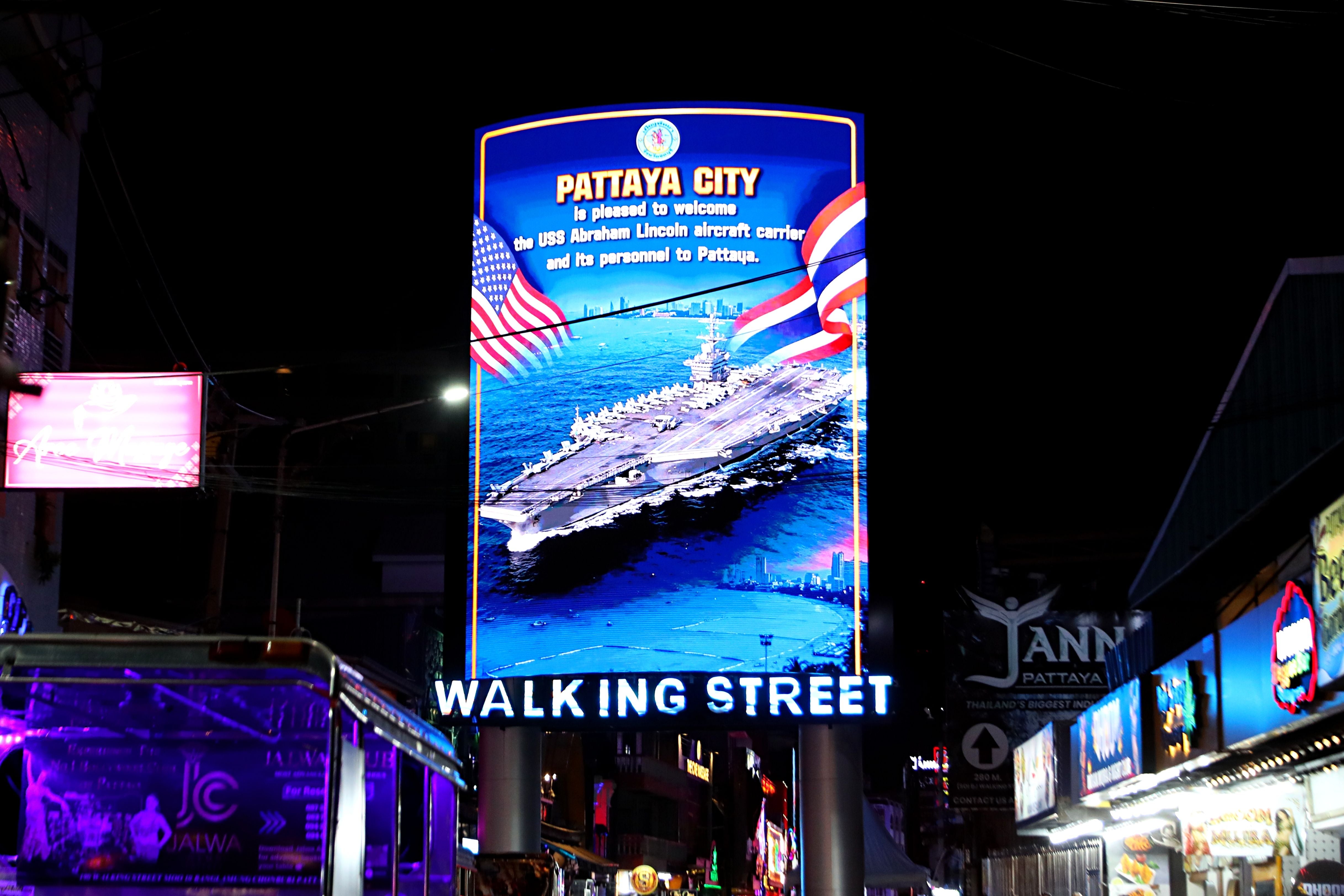Leuchtreklame begrüßt USS Abraham Lincoln in Pattaya auf der Walking Street bei Nacht.