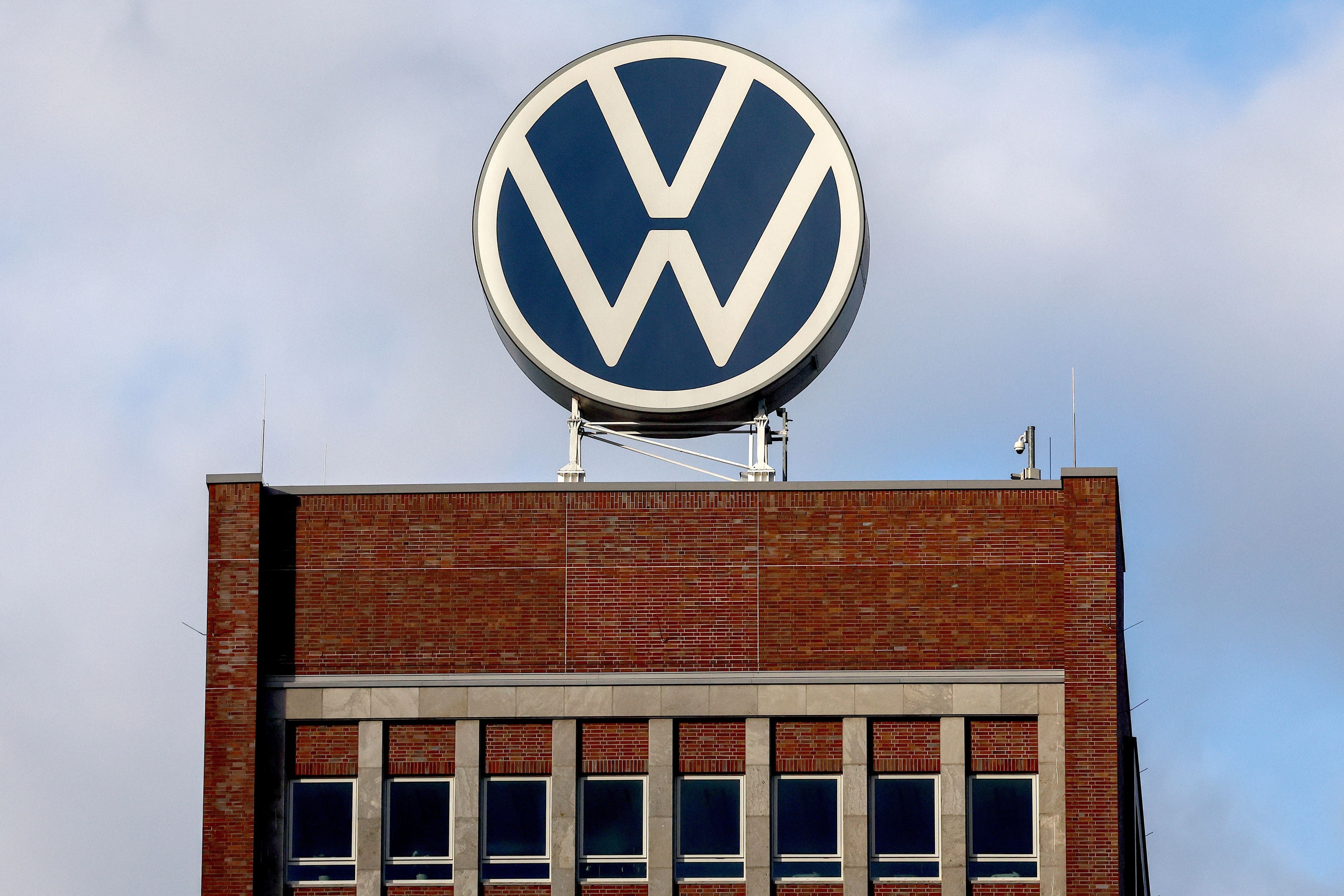 Das Volkswagen-Logo steht auf dem Dach eines Backsteingebäudes in Wolfsburg.