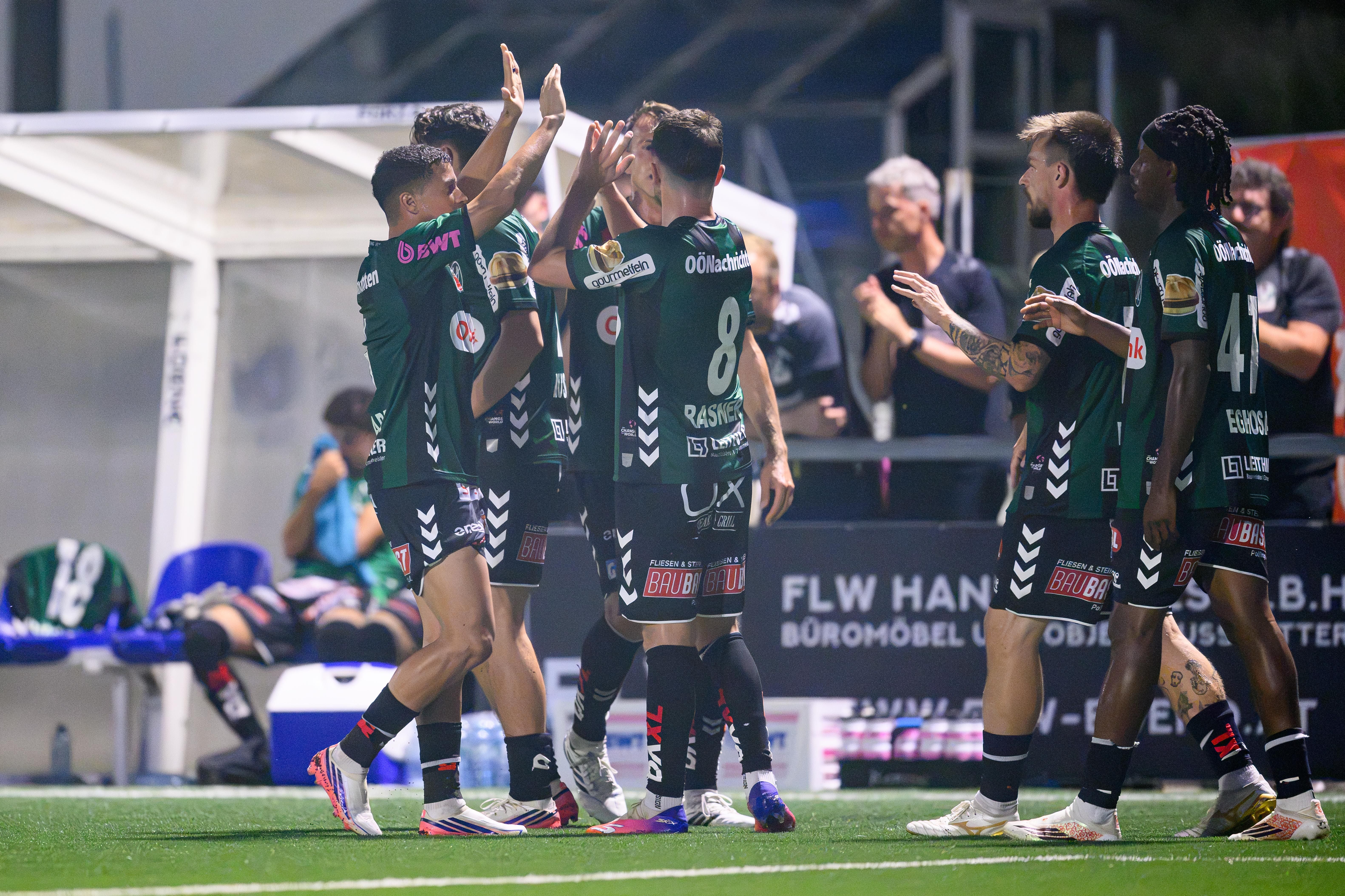 Mehrere Fußballspieler des SV Ried feiern gemeinsam ein Tor auf dem Spielfeld.
