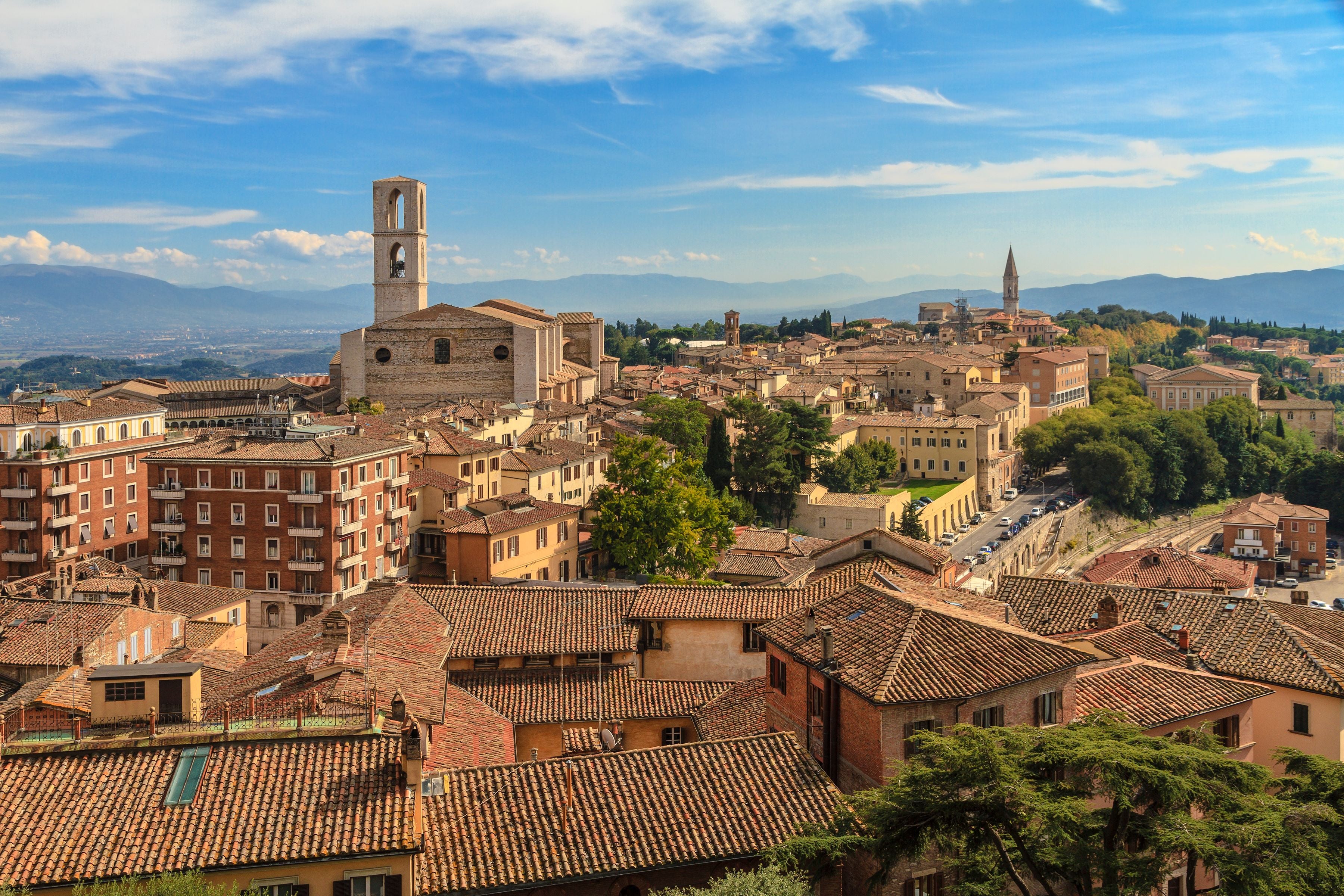 Blick über die Altstadt von Perugia mit roten Dächern und Kirchtürmen bei sonnigem Wetter.