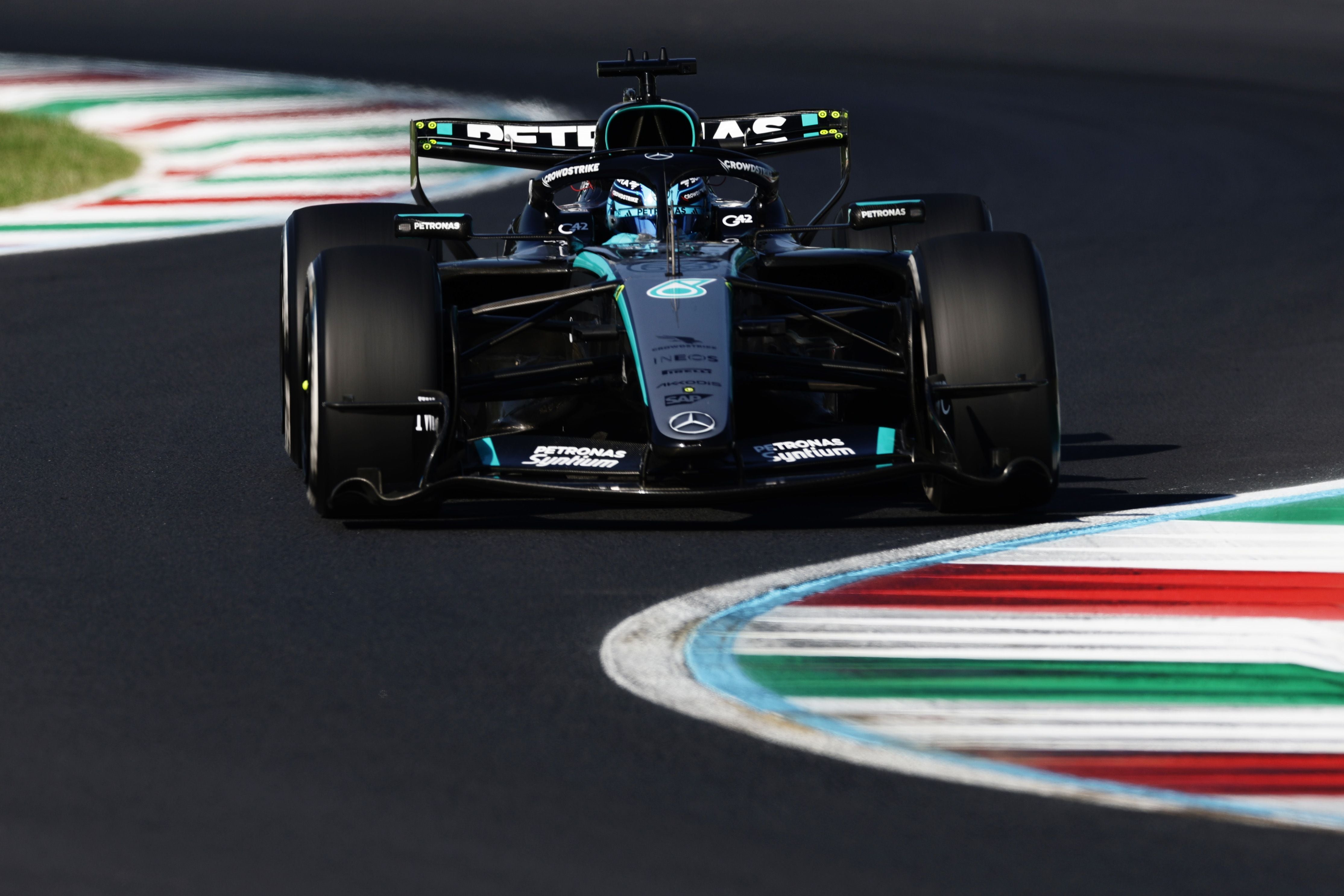 Ein schwarzer Mercedes-Formel-1-Wagen fährt auf der Monza-Rennstrecke über eine bunte Curbs.