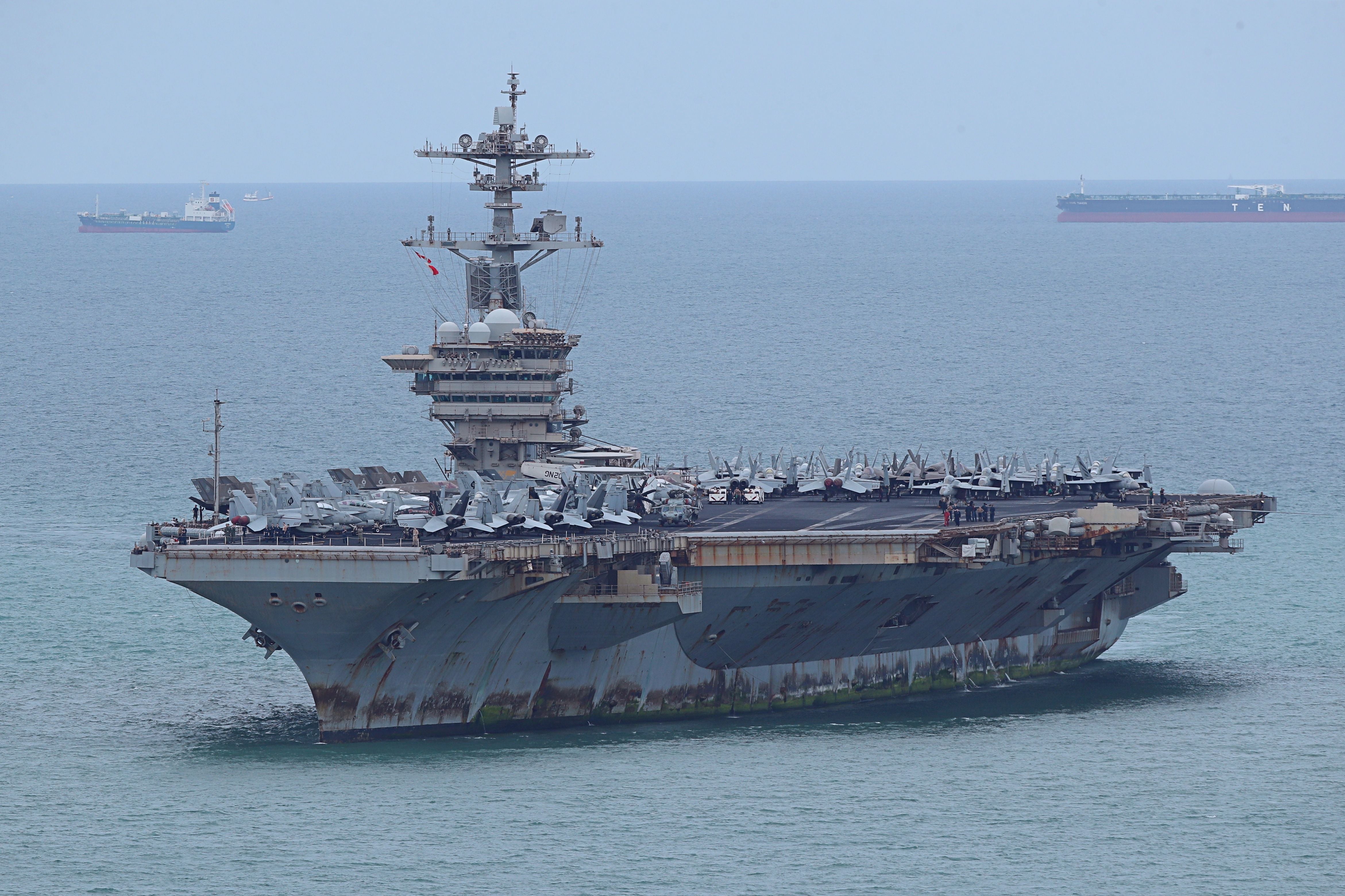 Flugzeugträger USS Abraham Lincoln mit Kampfjets an Deck fährt im Meer vor der Küste Thailands.