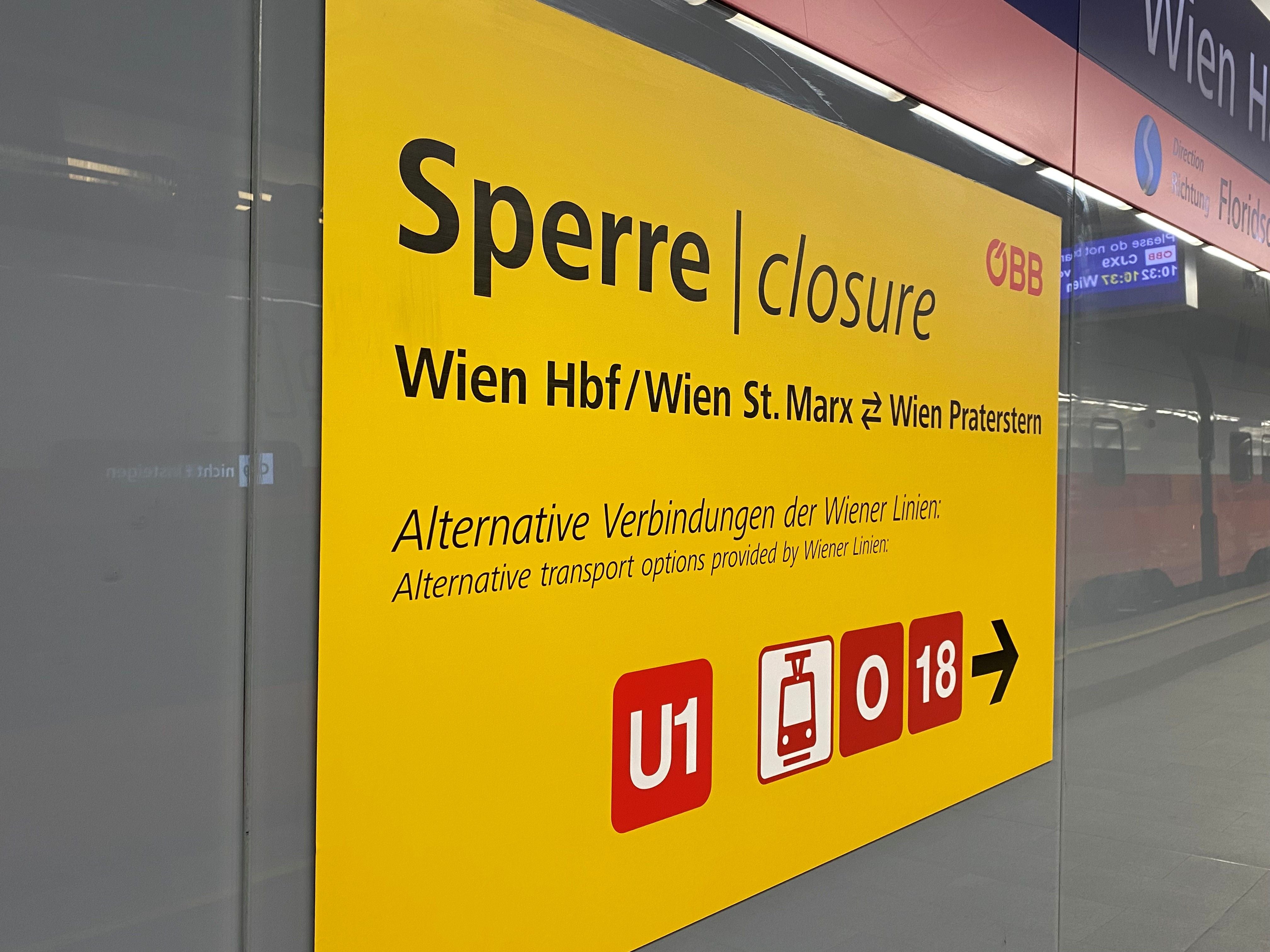 Gelbes Schild mit Hinweis auf eine Streckensperre zwischen Wien Hbf und Wien Praterstern.