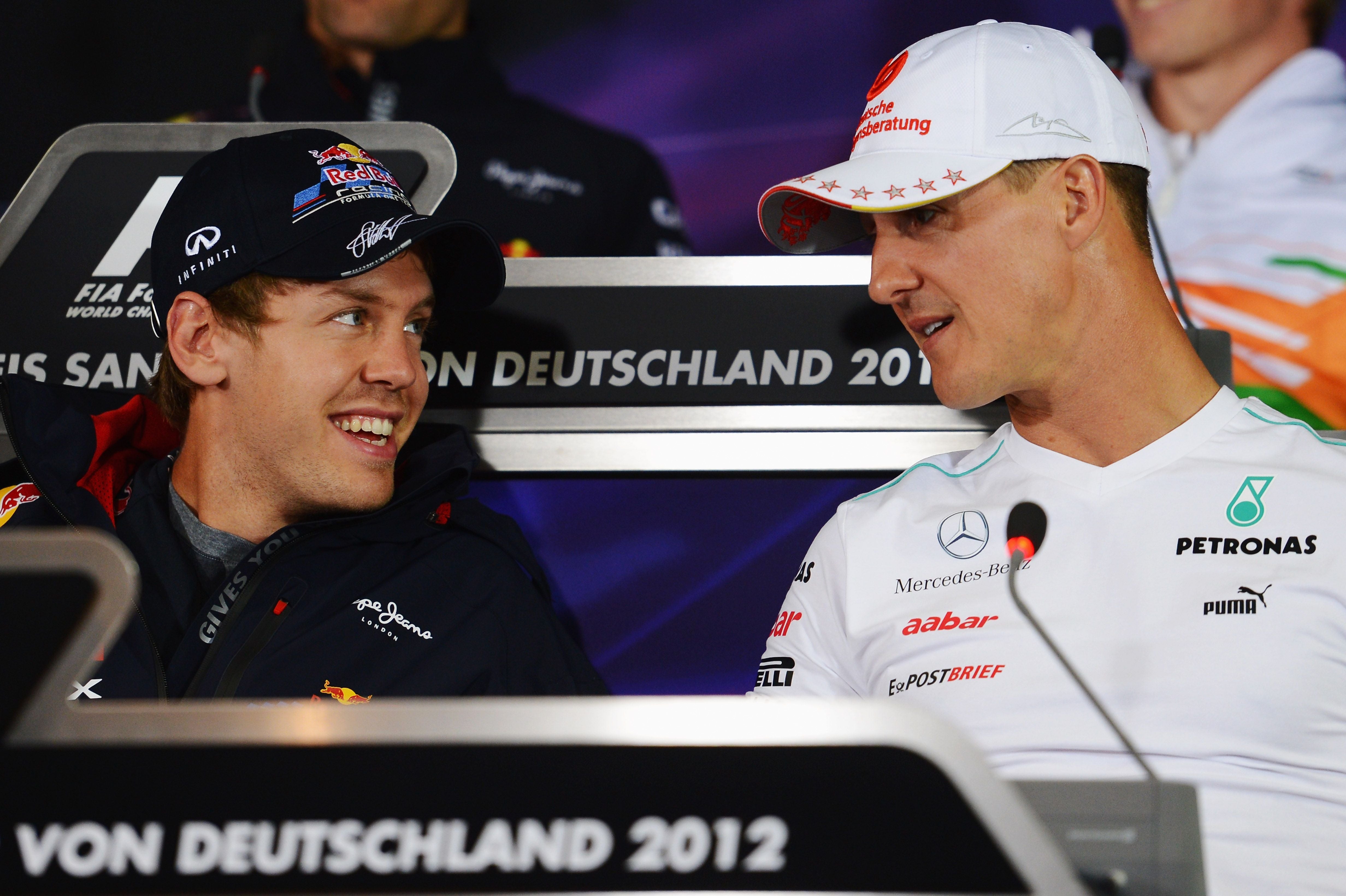 Sebastian Vettel und Michael Schumacher lachen bei einer Pressekonferenz 2012 in Hockenheim.