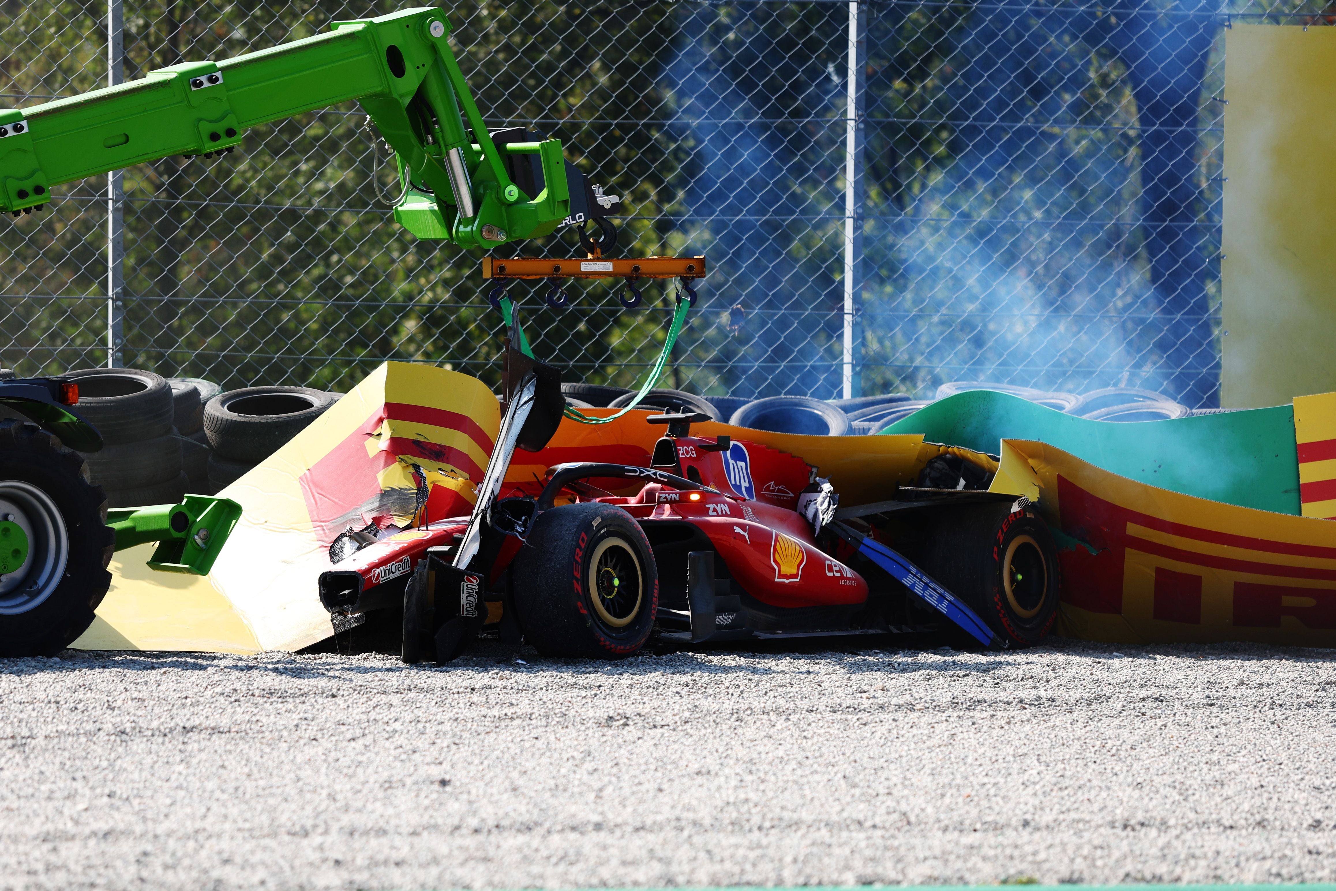 Ein roter Formel-1-Ferrari steht nach einem Unfall beschädigt in der Streckenbegrenzung.