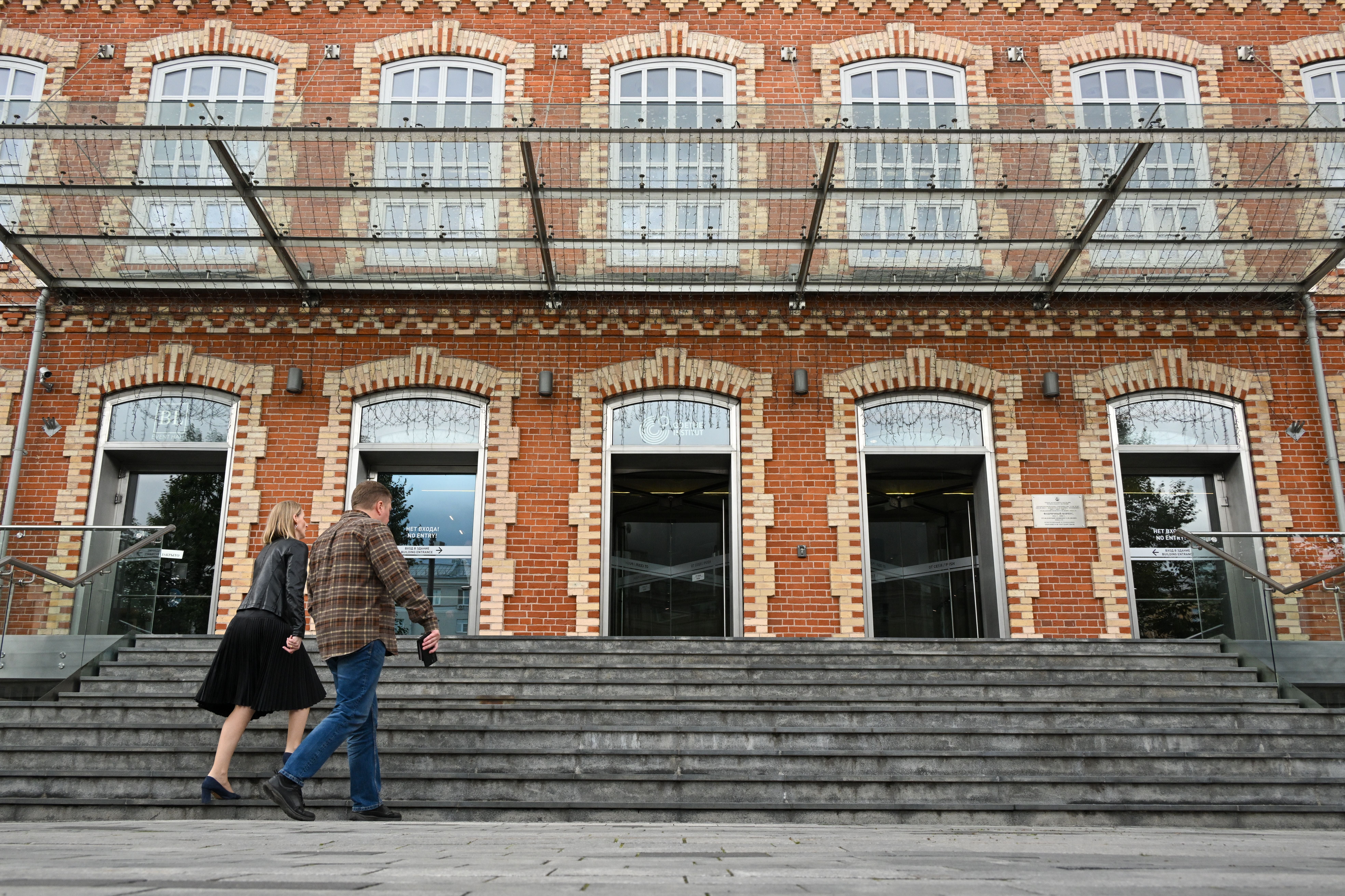 Zwei Personen gehen eine Treppe zum Goethe-Institut in Moskau hoch, Backsteinfassade im Hintergrund.