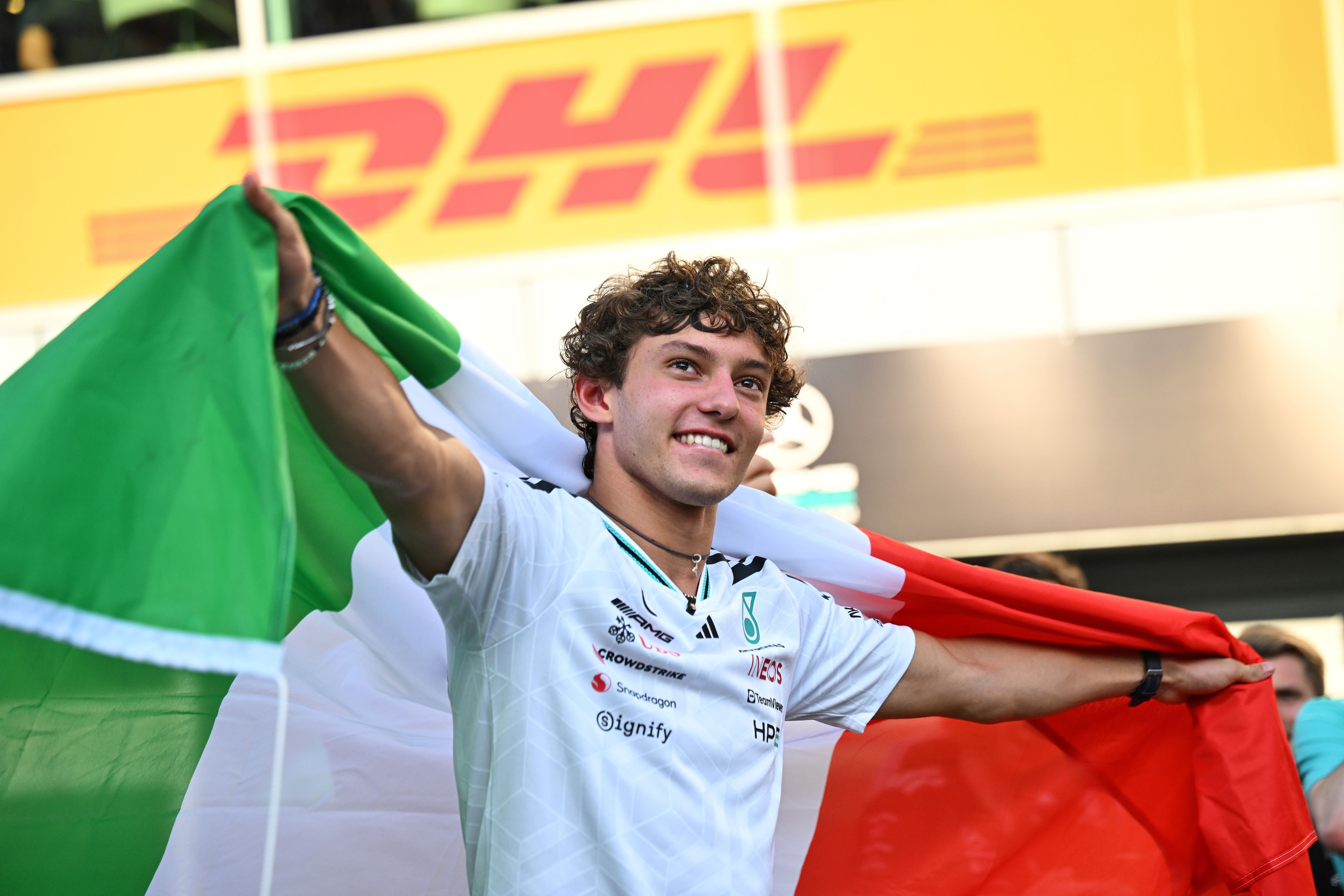 Ein junger Mann jubelt mit einer italienischen Flagge bei einem Formel-1-Rennen in Monza.