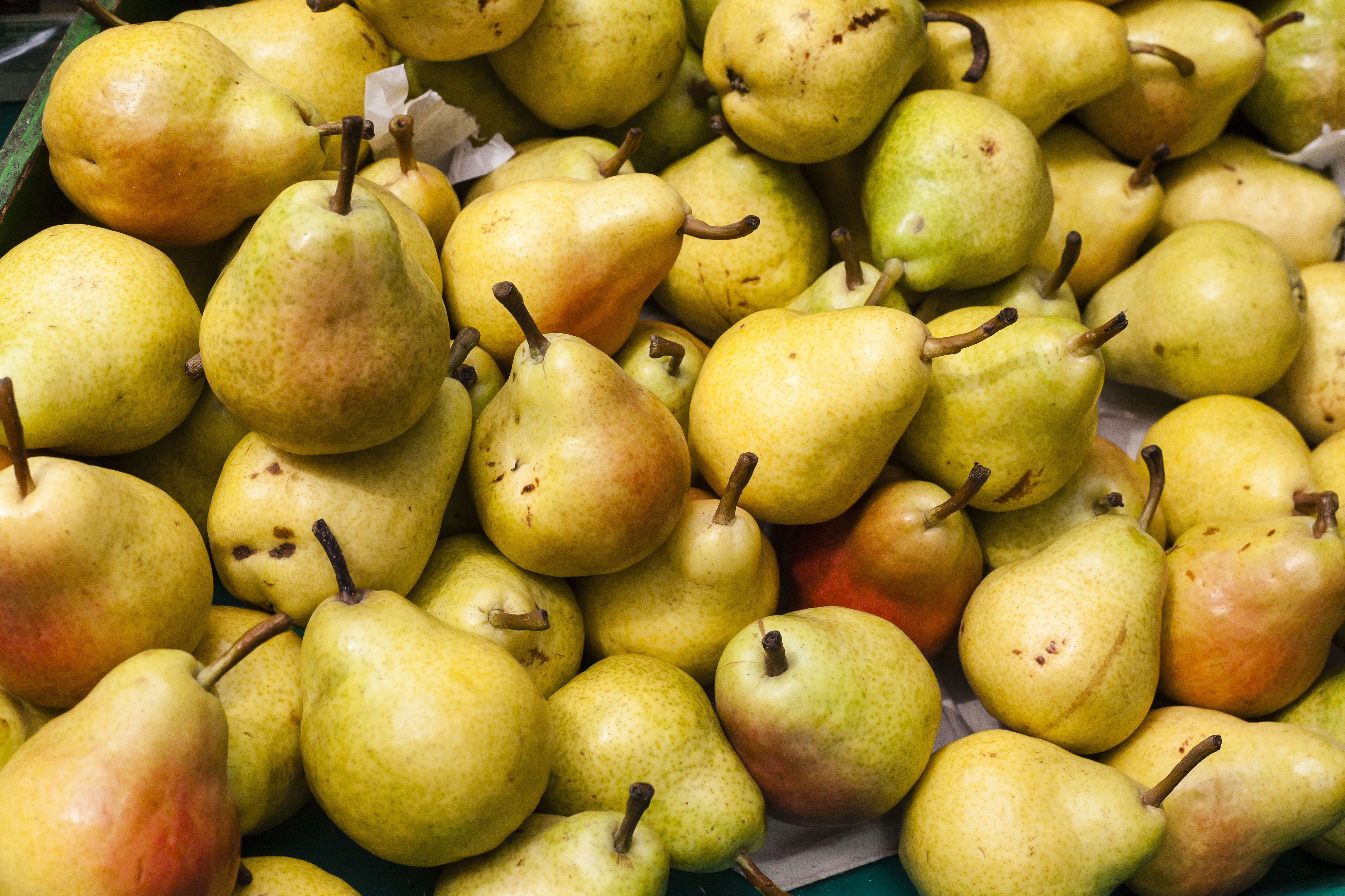 Viele reife Birnen liegen dicht aneinander auf einem Marktstand.