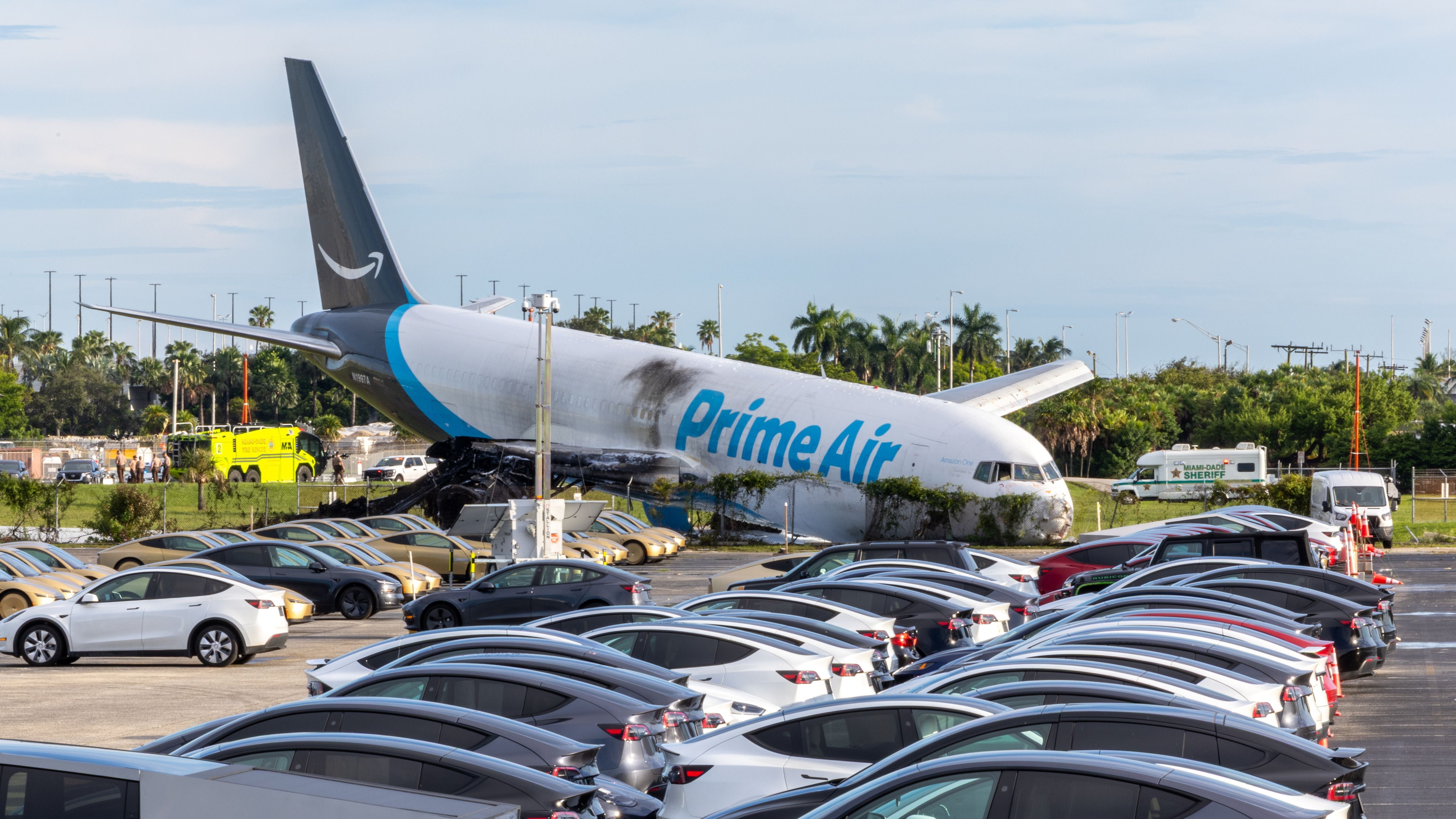 Ein Prime Air Frachtflugzeug steht nach einer Bruchlandung auf der Nase nahe geparkter Autos.