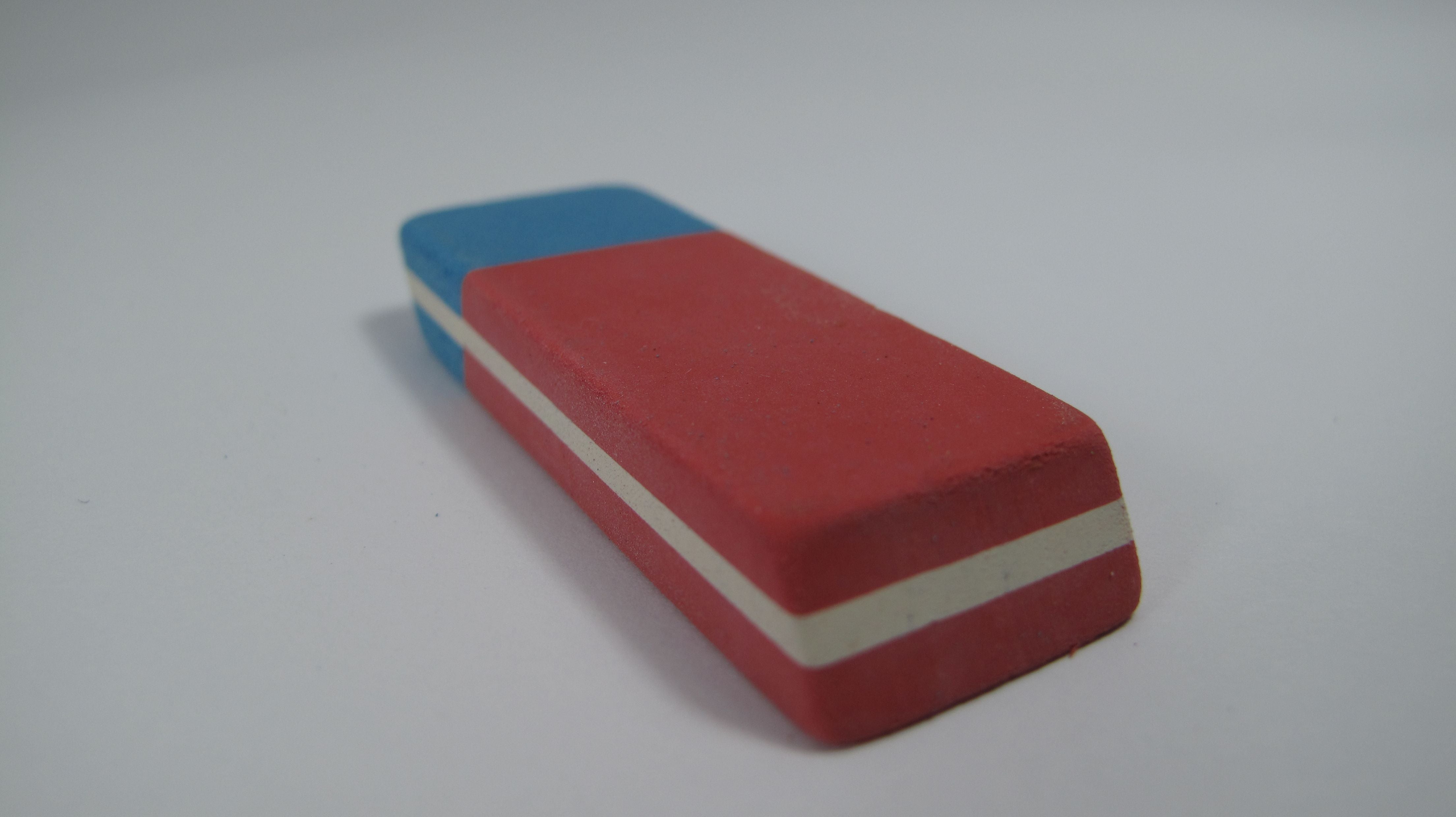 Rot-blauer Radiergummi mit weißem Streifen auf weißem Hintergrund.