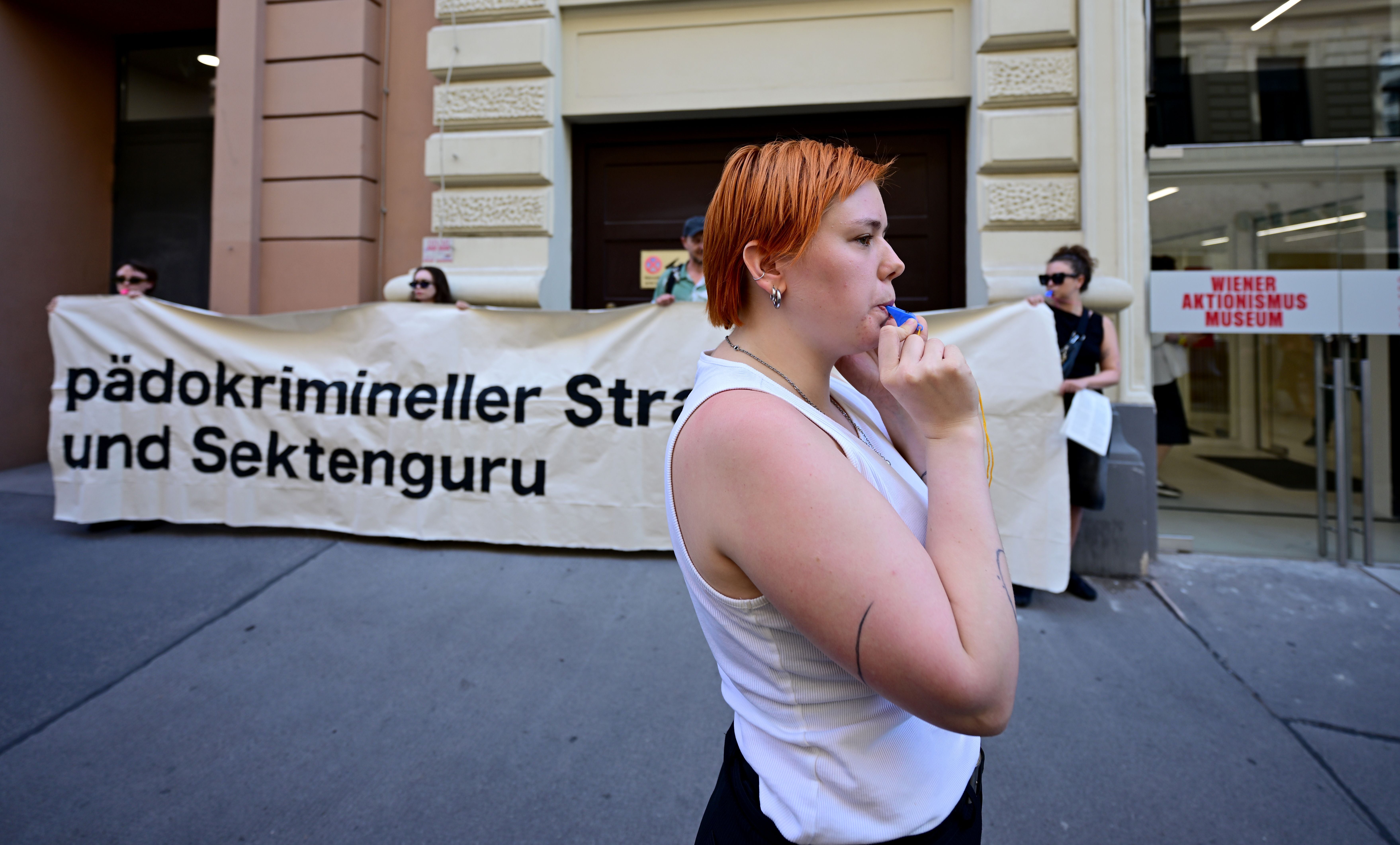 Protestierende mit Banner vor dem Wiener Aktionismus Museum bei einer Kundgebung zur Otto-Muehl-Ausstellung.