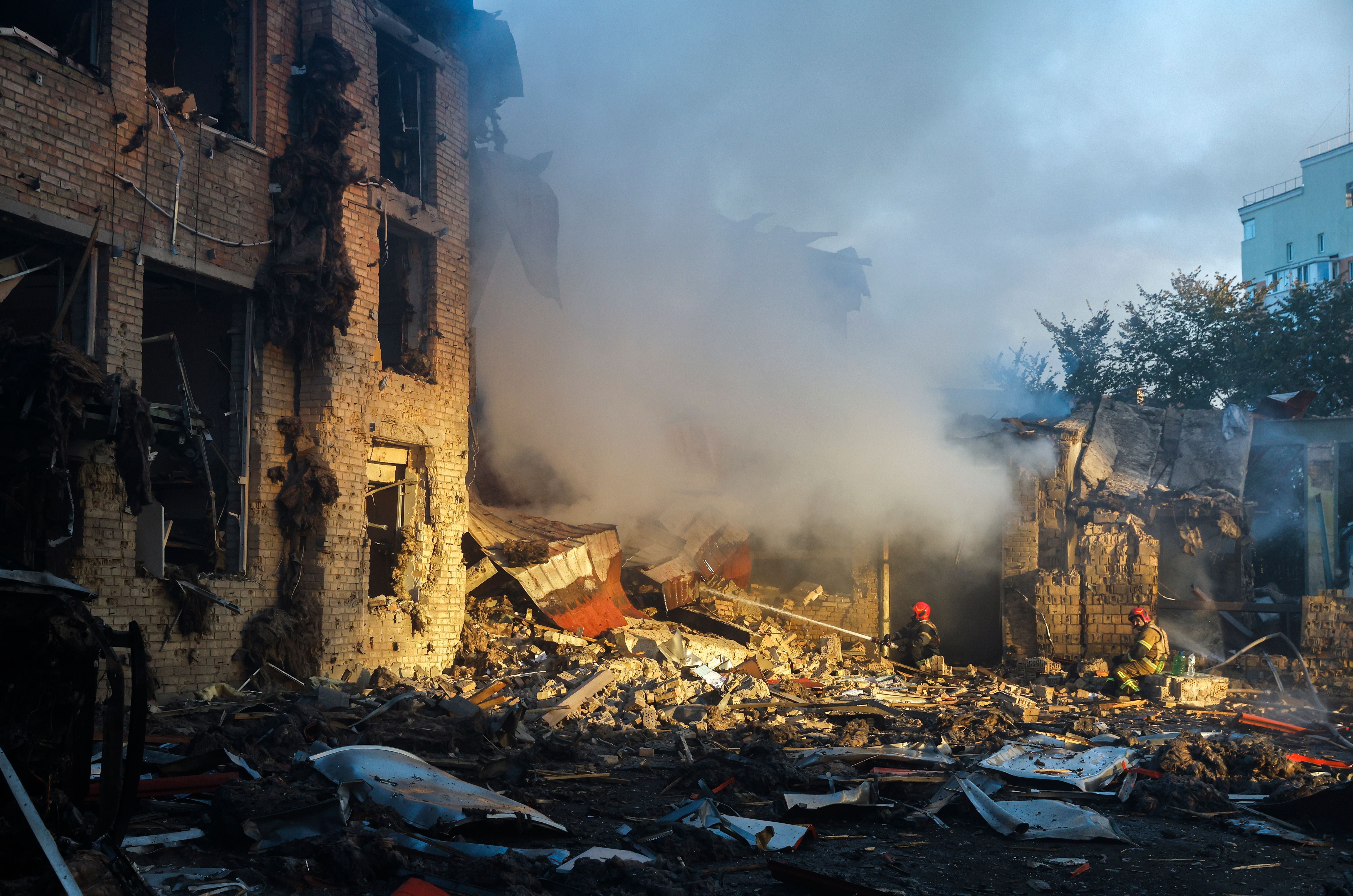Zerstörtes Gebäude mit Trümmern, Rauch und Feuerwehrleuten nach einem Angriff in Kiew.