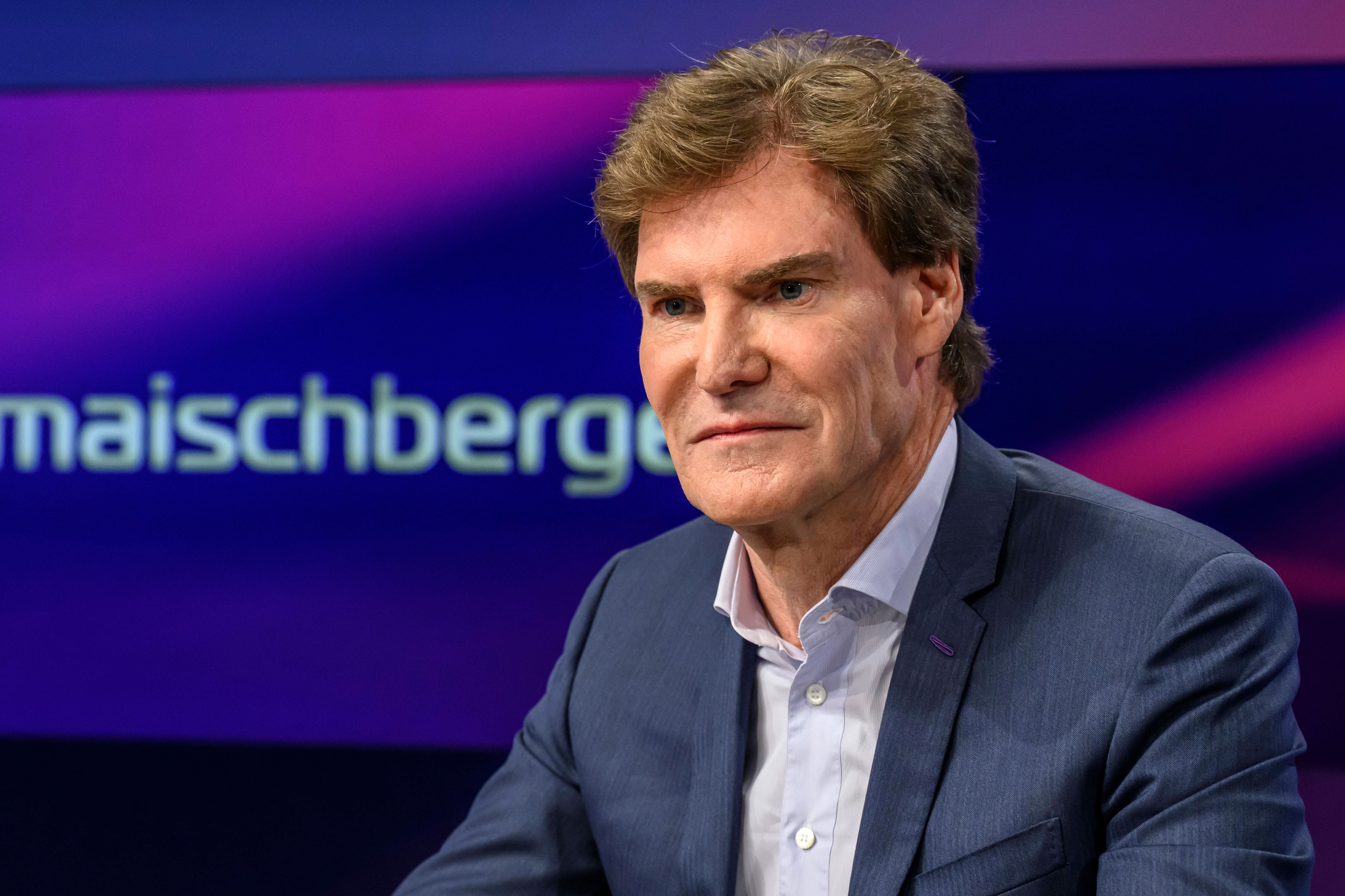Ein Mann im Anzug sitzt in einem Fernsehstudio mit dem Schriftzug "maischberger" im Hintergrund.
