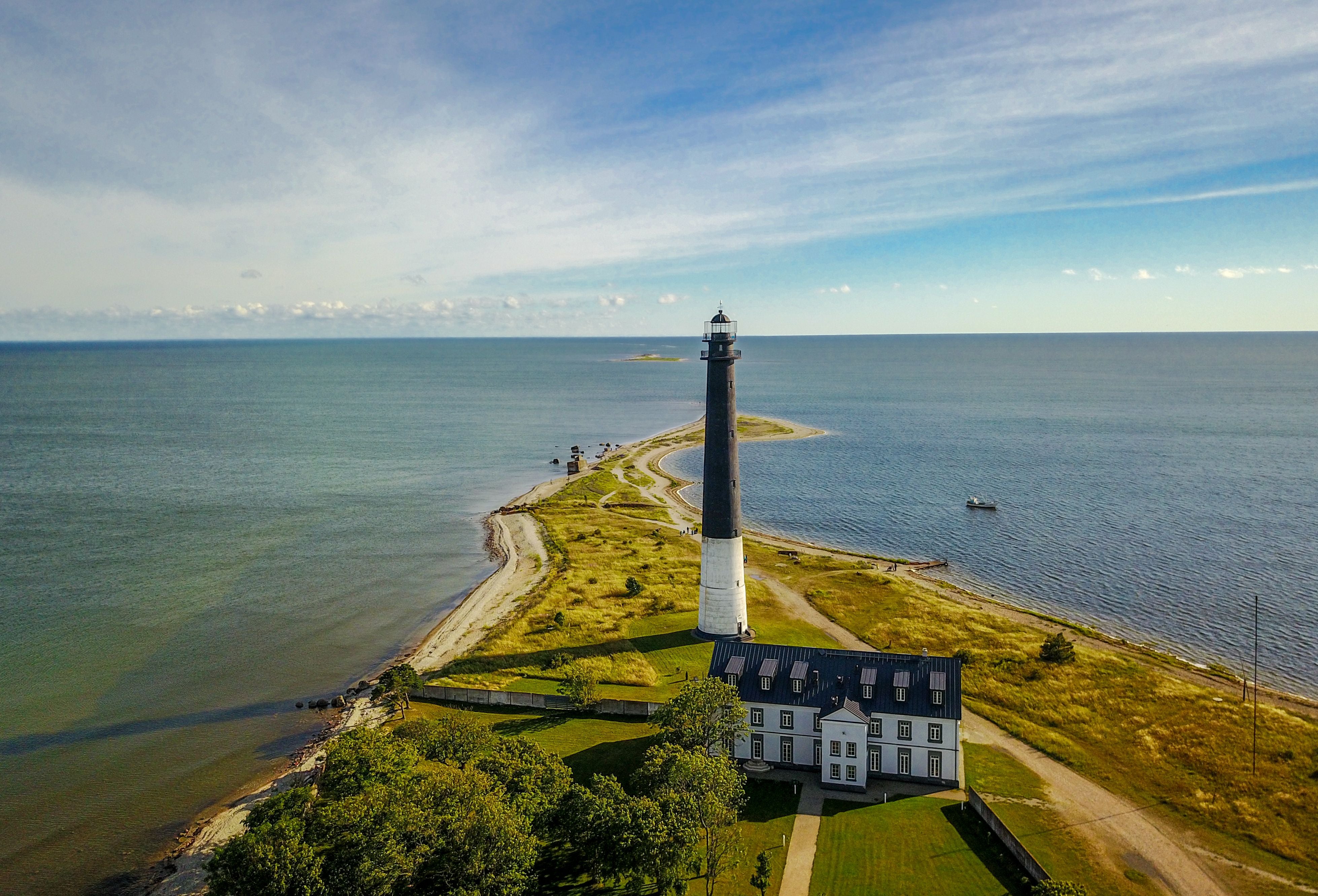 Luftaufnahme eines Leuchtturms an der Südspitze einer Halbinsel auf Saaremaa, umgeben von Meer.