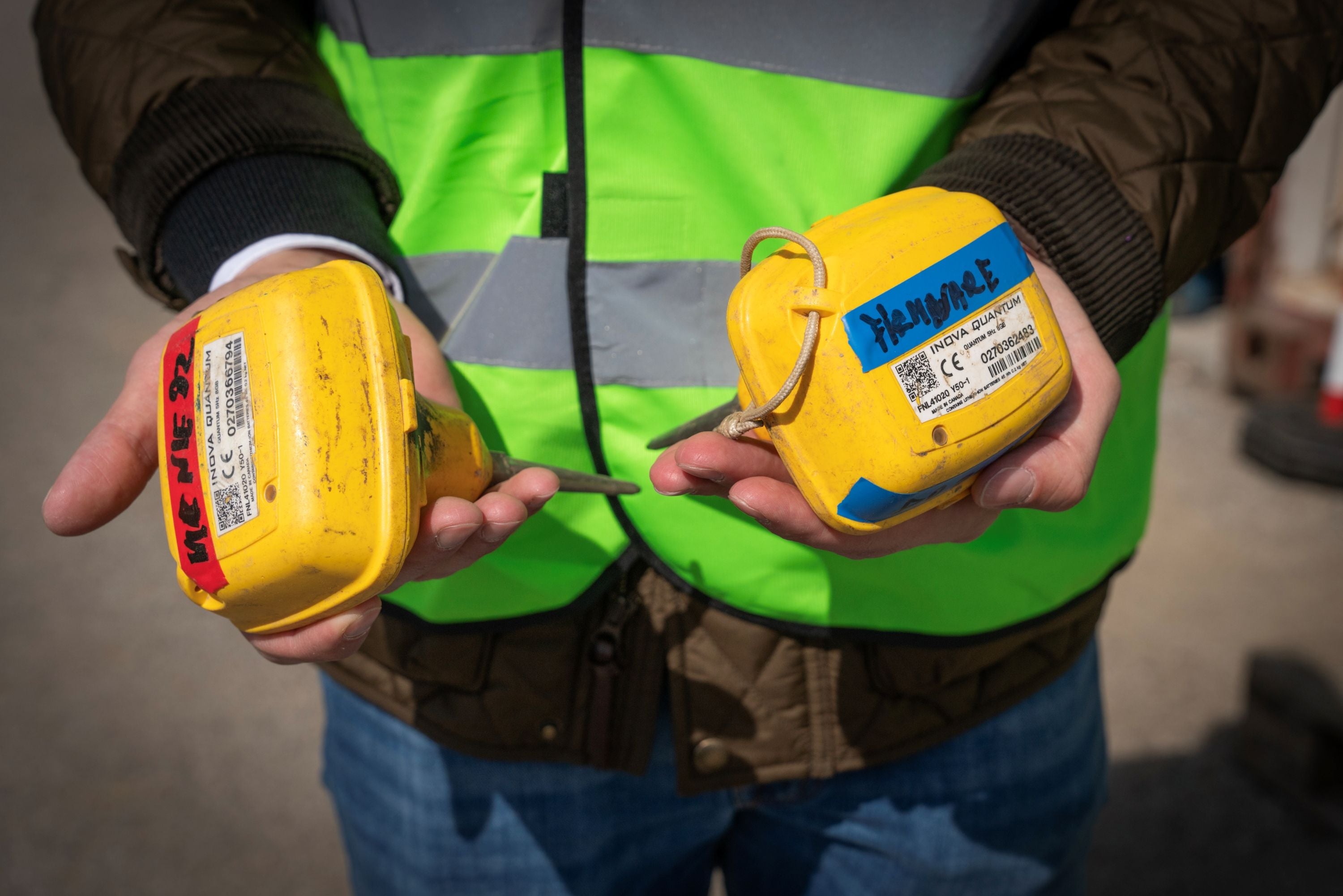 Person hält zwei gelbe Geothermie-Messgeräte in den Händen, trägt Warnweste.
