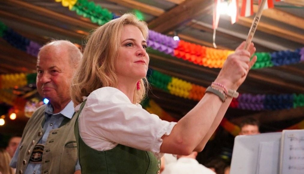 Meinl-Reisinger in Tracht schlägt mit einem Holzstab auf eine Trommel bei einem Fest.