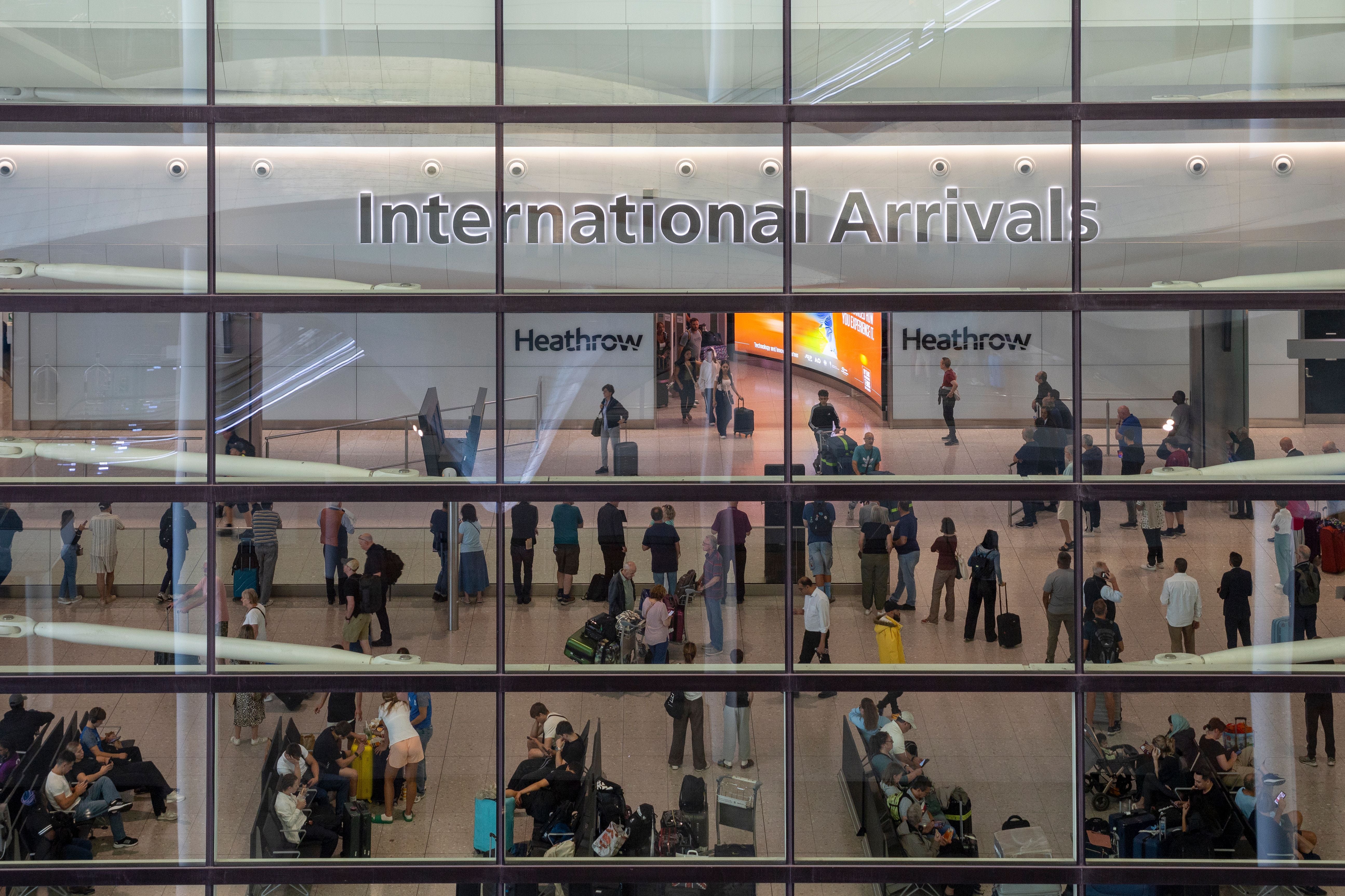 Menschen warten und empfangen ankommende Passagiere im Terminal 2 am Flughafen Heathrow.