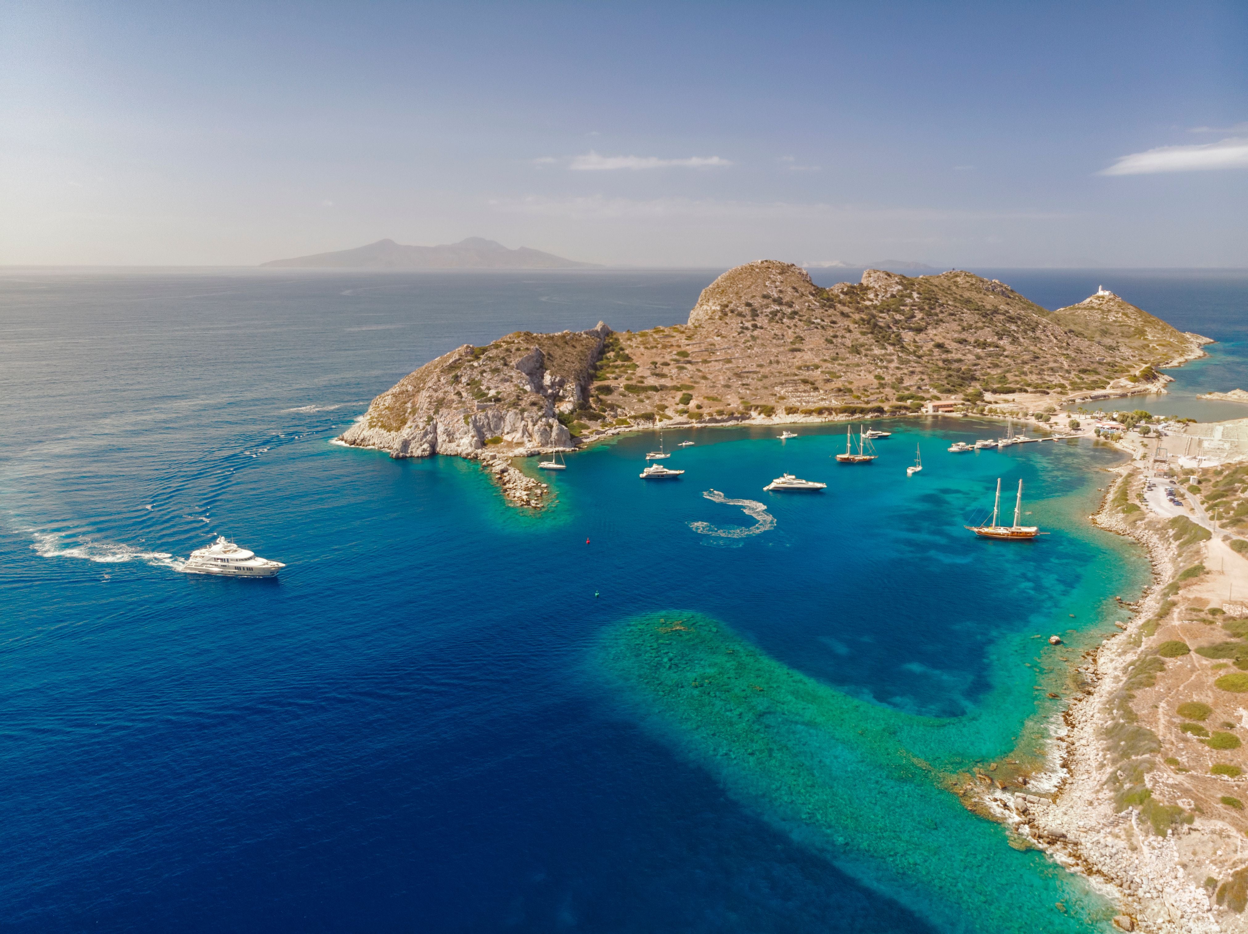Luftaufnahme einer Bucht mit Yachten und türkisblauem Wasser bei Knidos auf der Datça-Halbinsel.