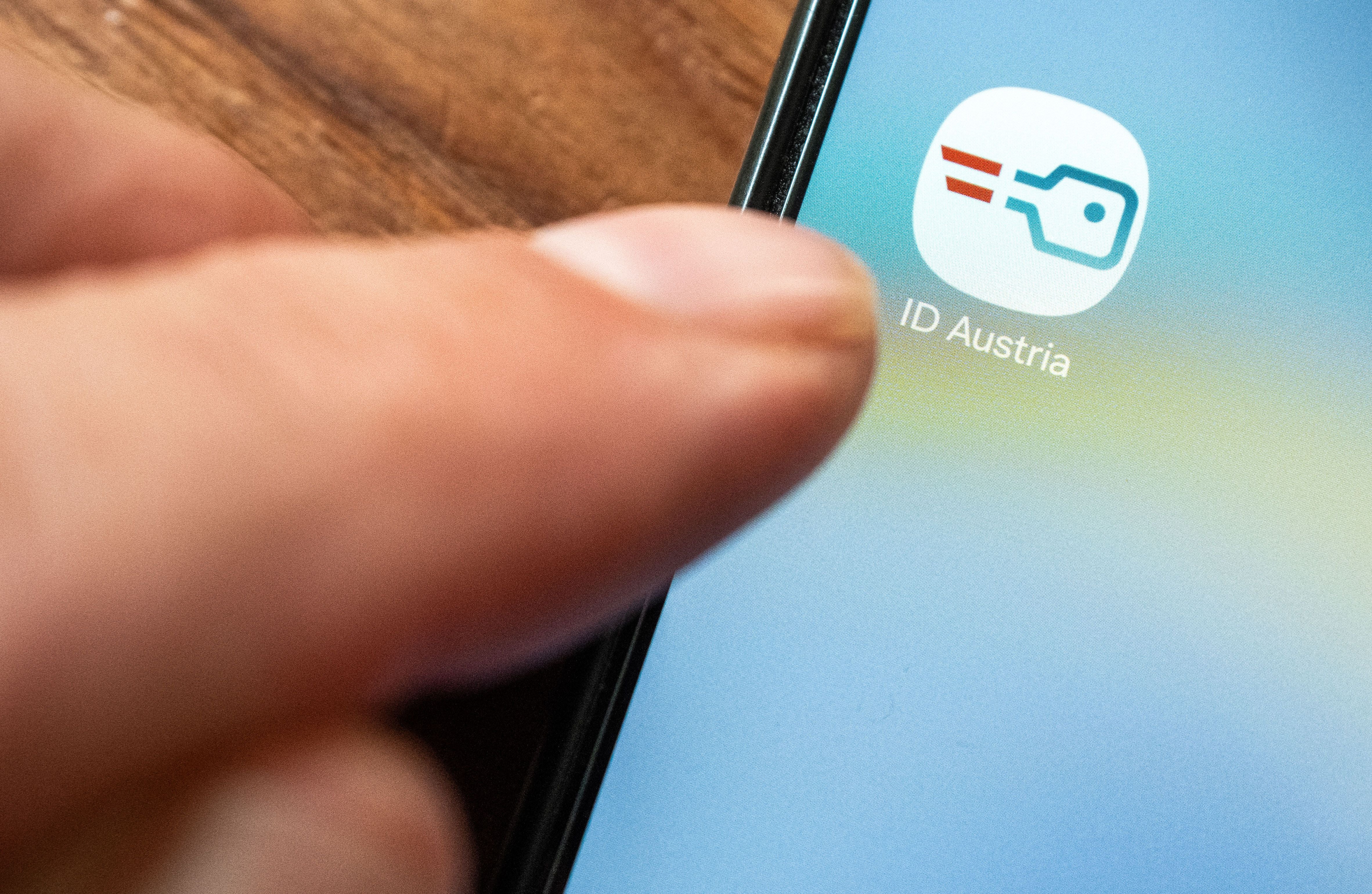 Finger tippt auf das App-Symbol „ID Austria“ auf einem Smartphone-Bildschirm.
