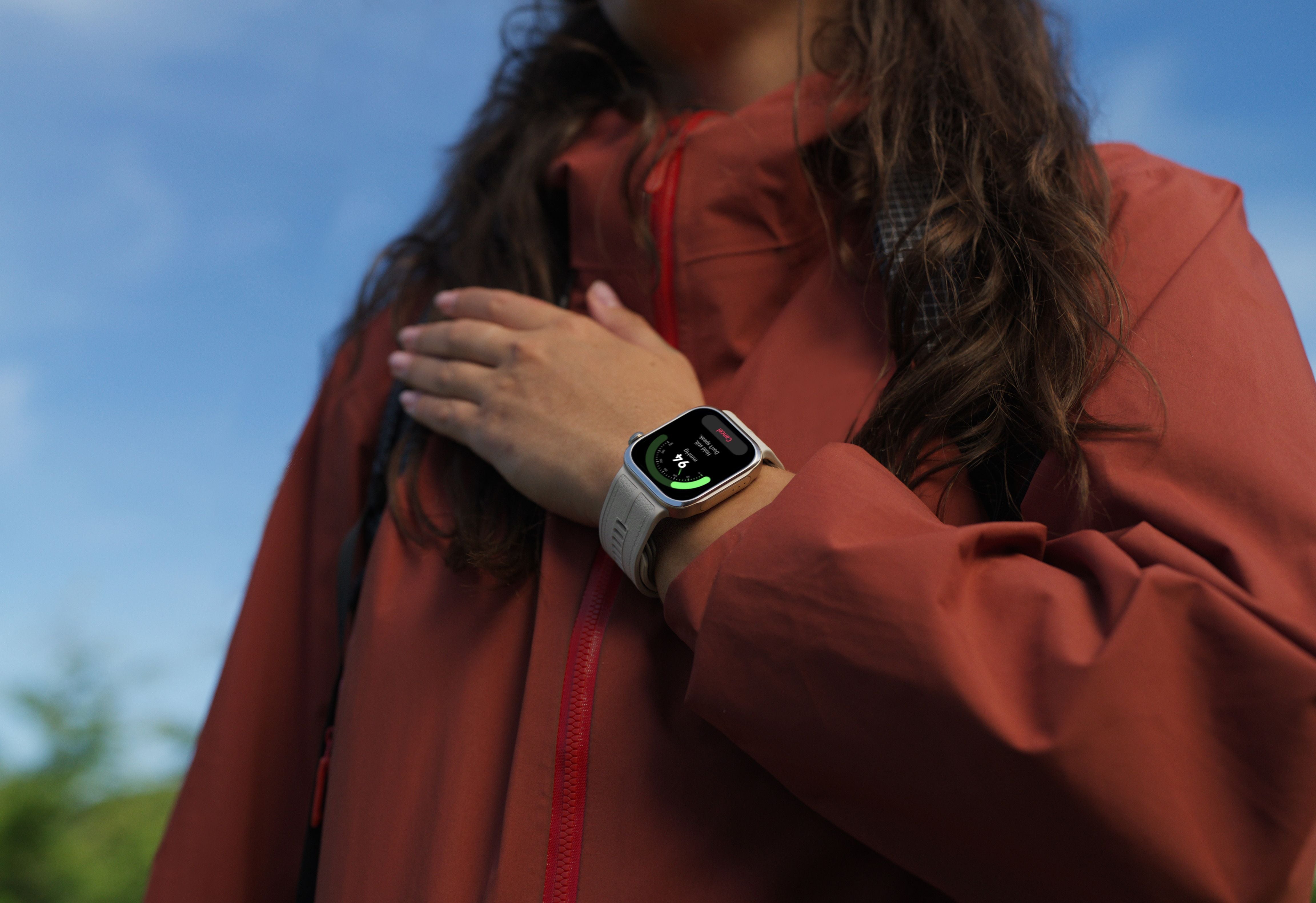 Frau mit roter Jacke trägt eine HUAWEI WATCH D3 mit Aktivitätsanzeige am Handgelenk.