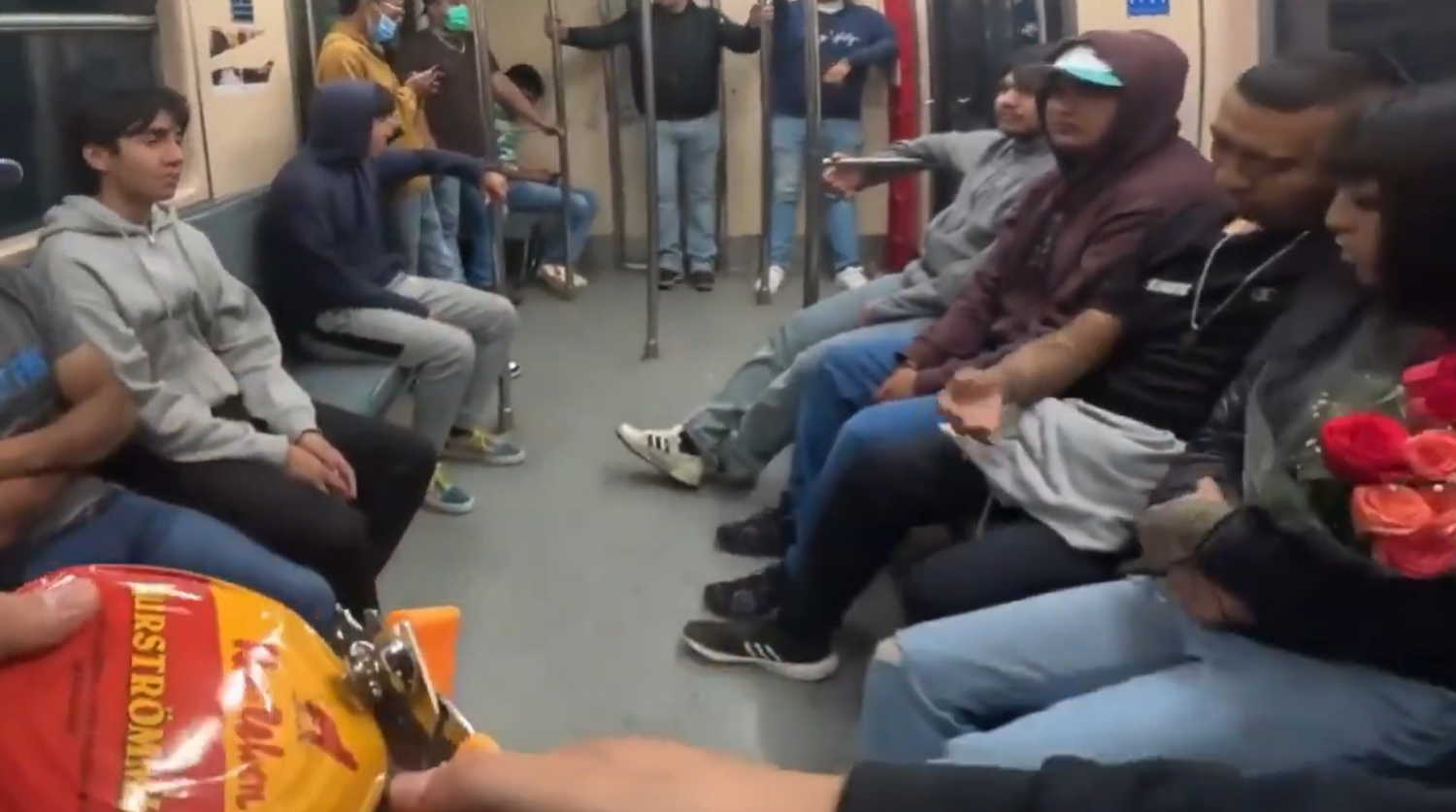 Mehrere Menschen sitzen in einer U-Bahn in Mexiko, vorne hält jemand eine Dose Surströmming.