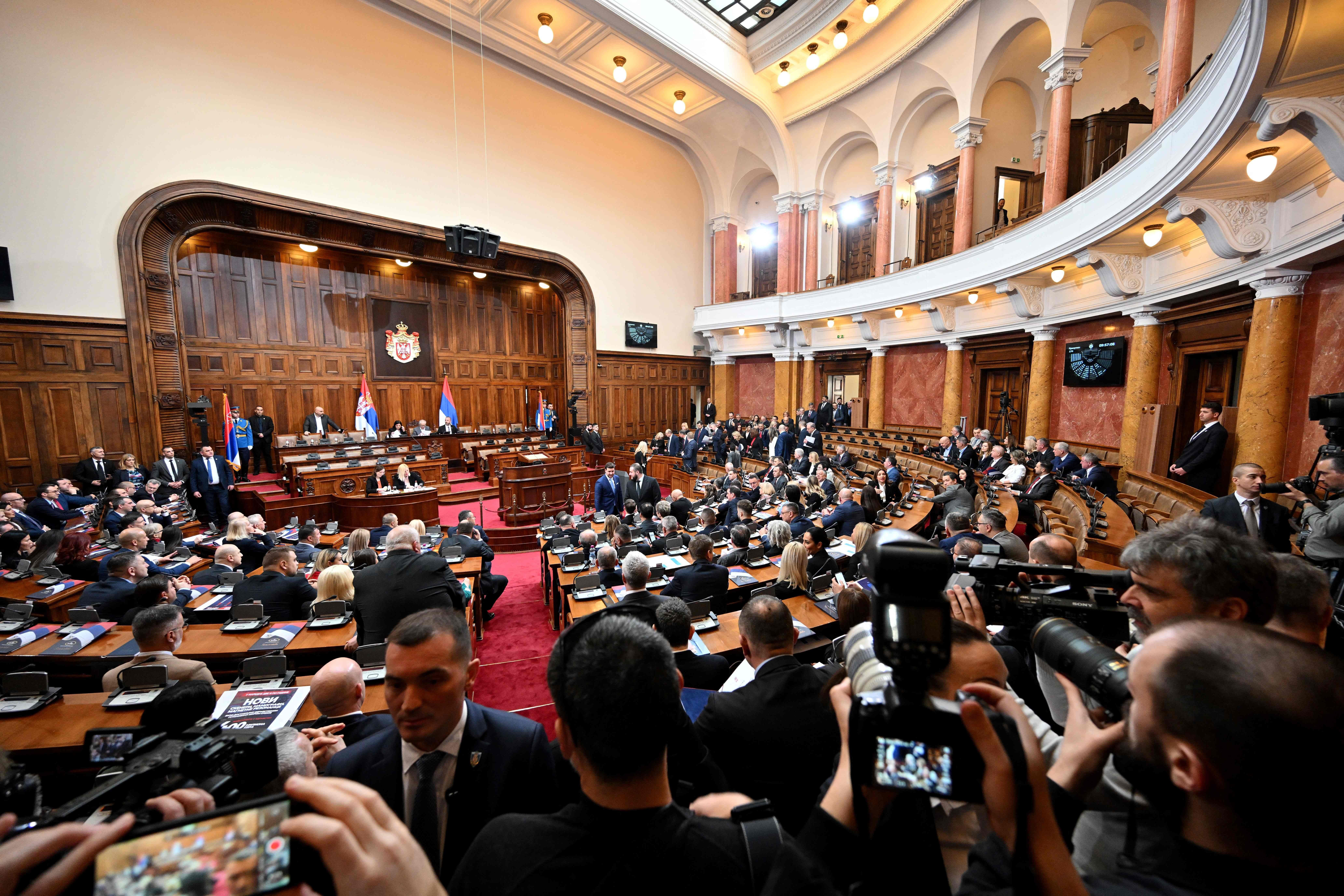 Das serbische Parlament in Belgrad während einer Sitzung mit vielen Abgeordneten und Fotografen.