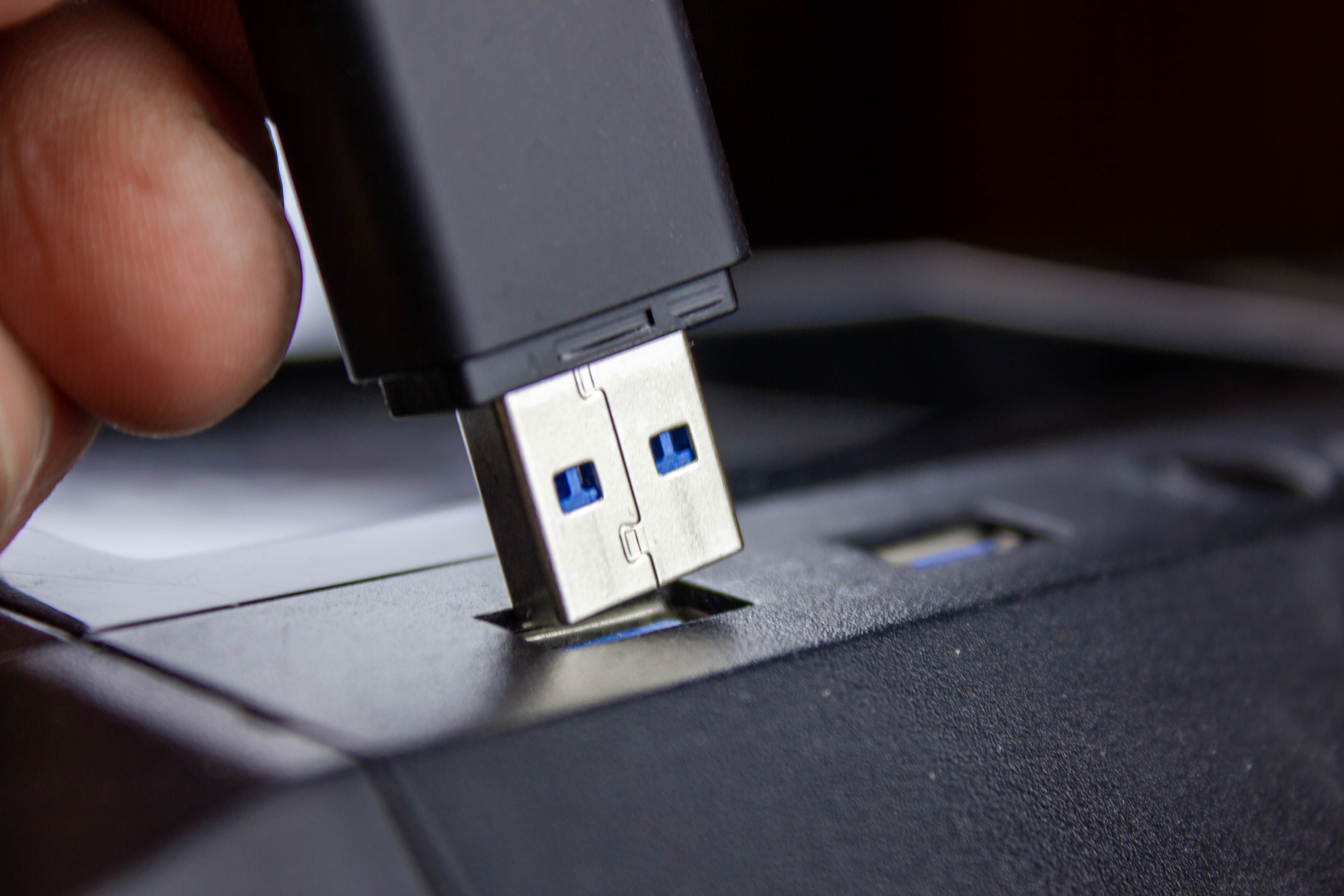 Ein USB-Stick wird in einen USB-Anschluss eines Computers gesteckt.