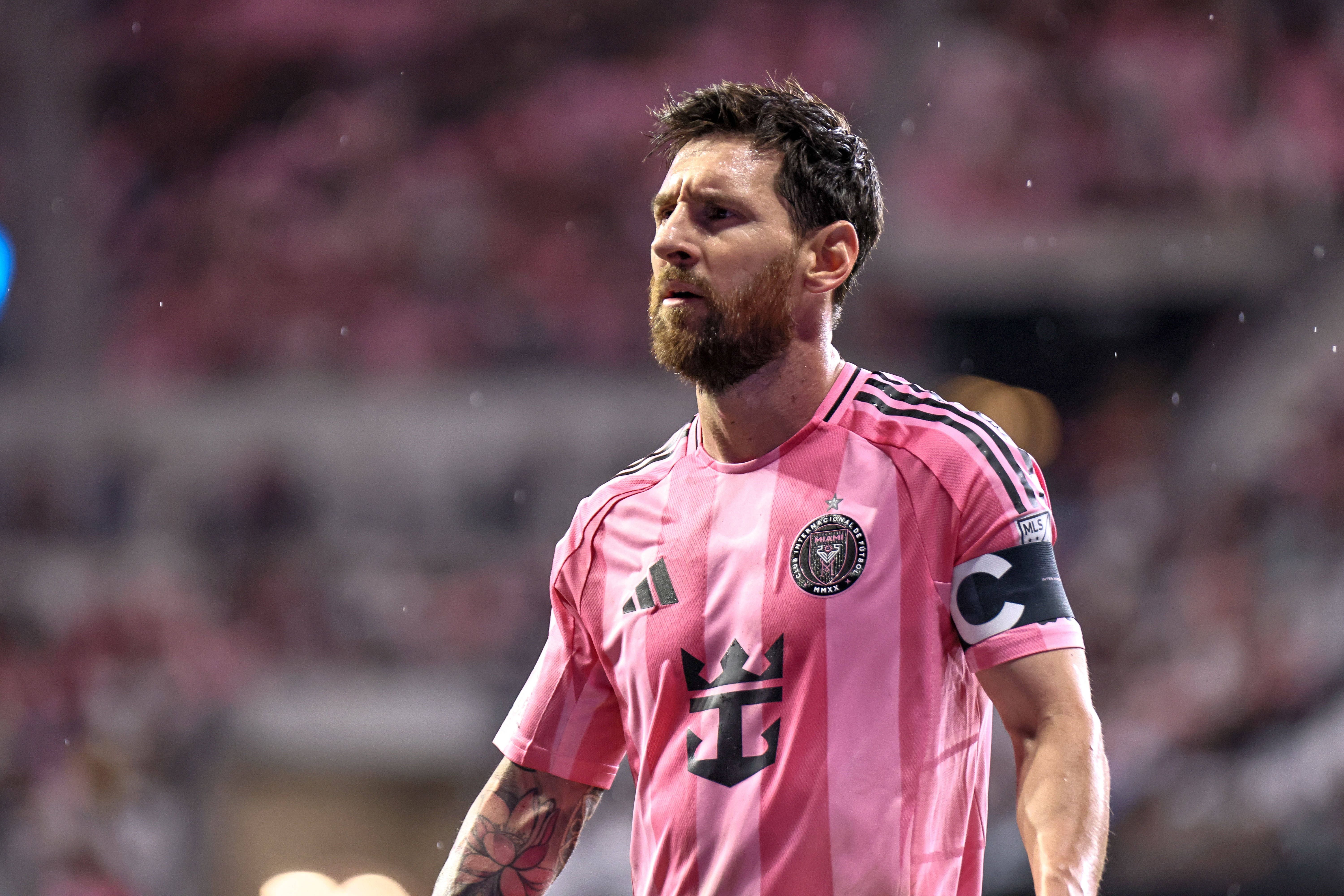 Fußballspieler im pinken Inter Miami Trikot mit Kapitänsbinde auf dem Spielfeld.
