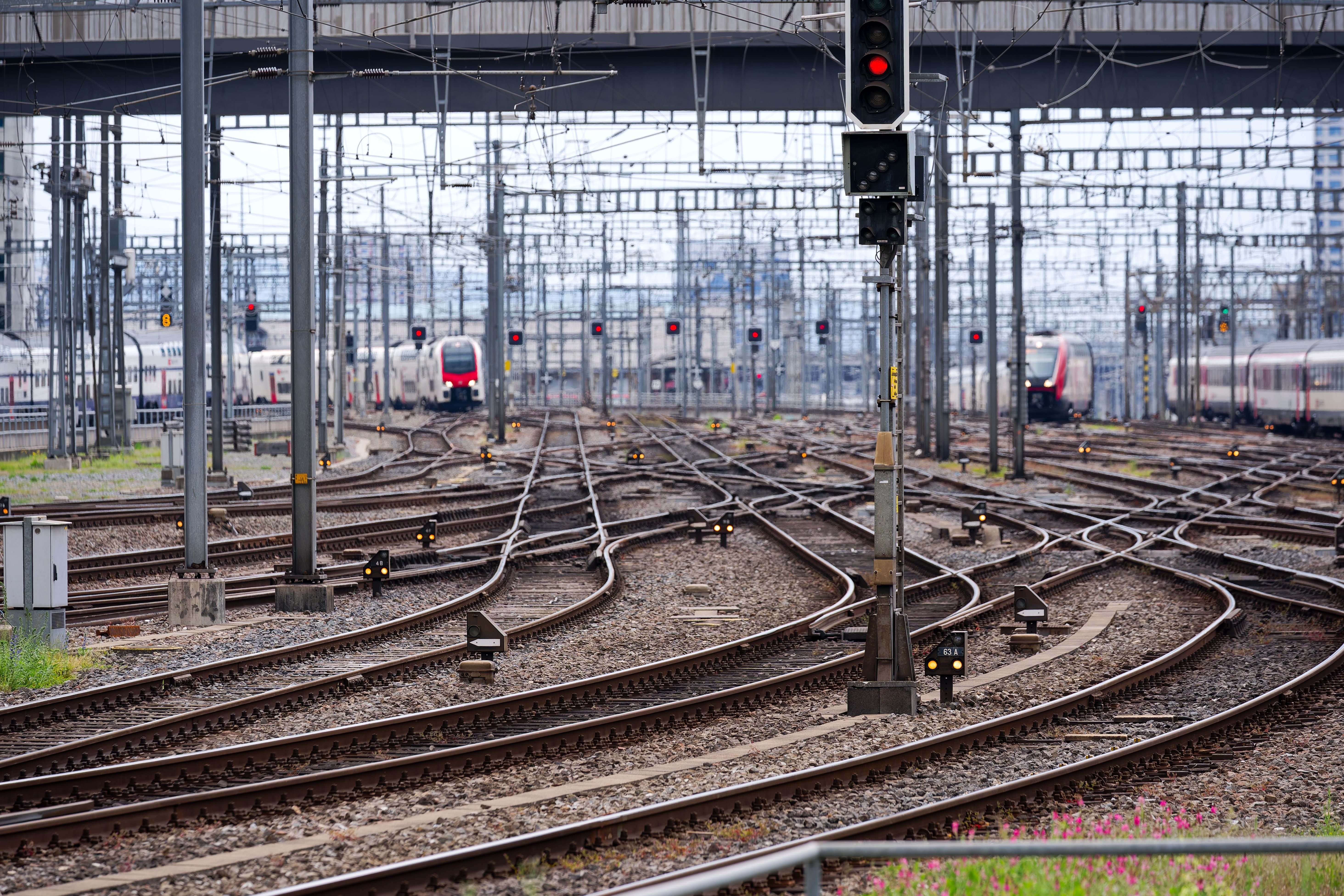 Viele Bahngleise mit Zügen und Signalen am Hauptbahnhof Zürich an einem bewölkten Tag.