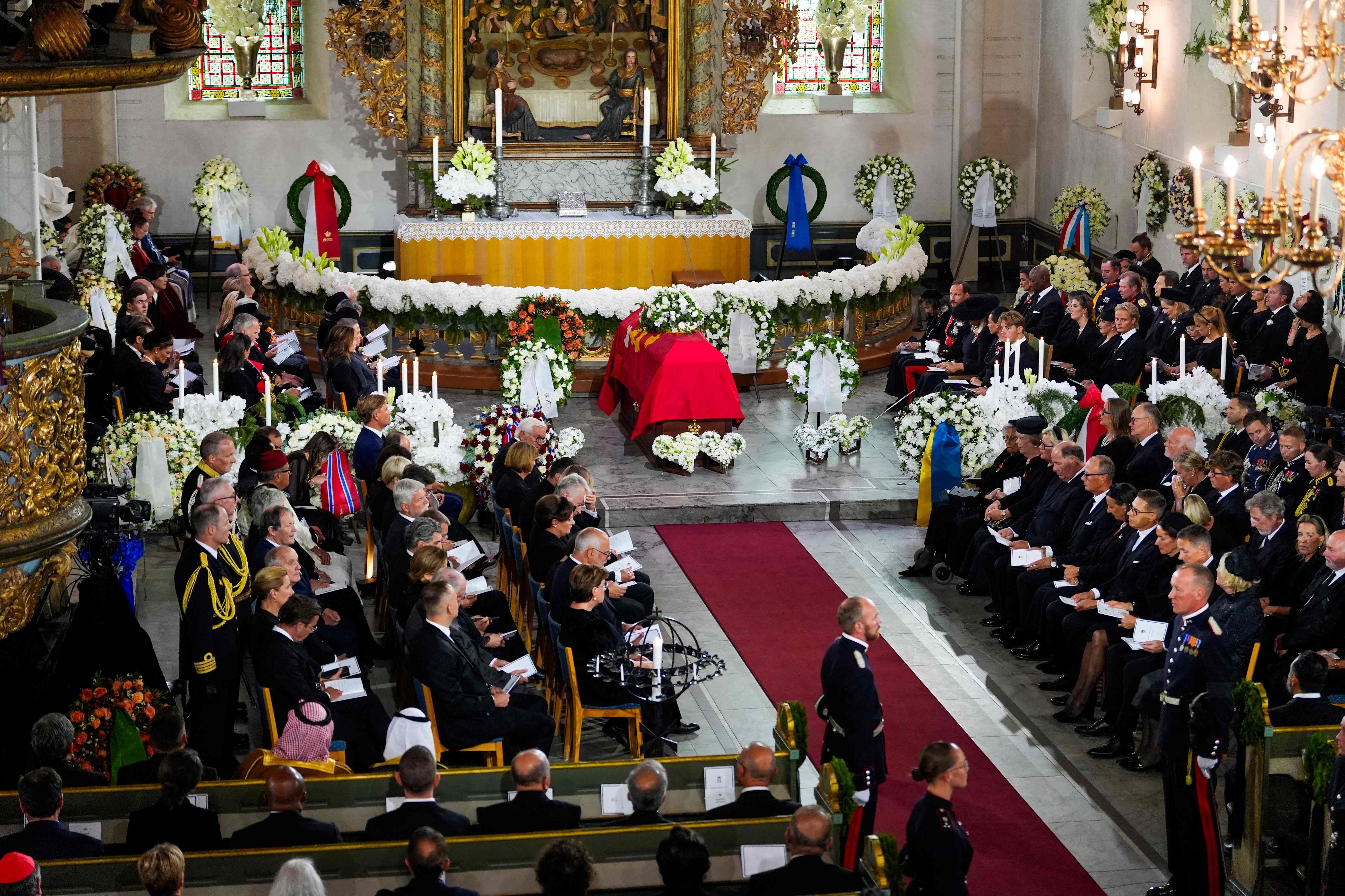 Der Sarg von König Harald V steht umgeben von Blumen in einer vollen Kathedrale bei der Trauerfeier.