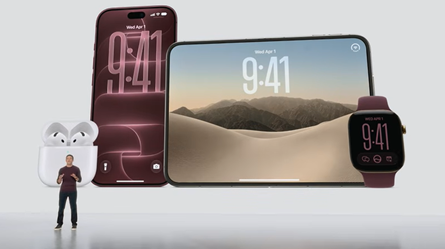 Ein Mann steht vor übergroßen Darstellungen von iPhone, iPad, AirPods und Apple Watch.