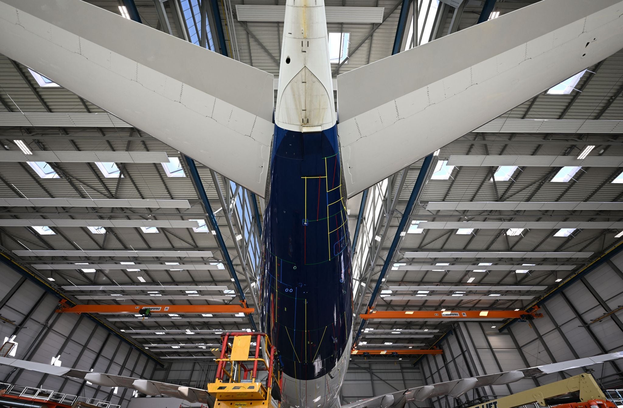 Das Heck eines Airbus A330 mit Markierungen steht in einem Hangar zur Installation einer Spezialfolie.